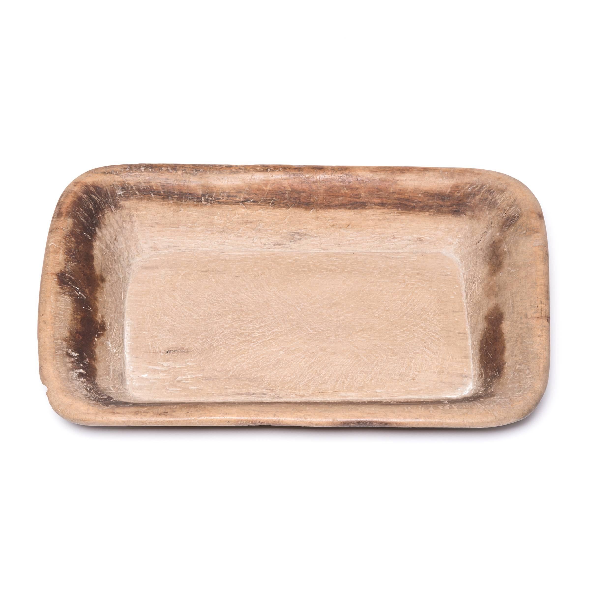 Created from a single block of wood, this hundred-year-old tray made in Shanxi province charms with its rusticity and organic form. Once used by merchants to showcase their wares, the tray has aged beautifully, marked with time and history,