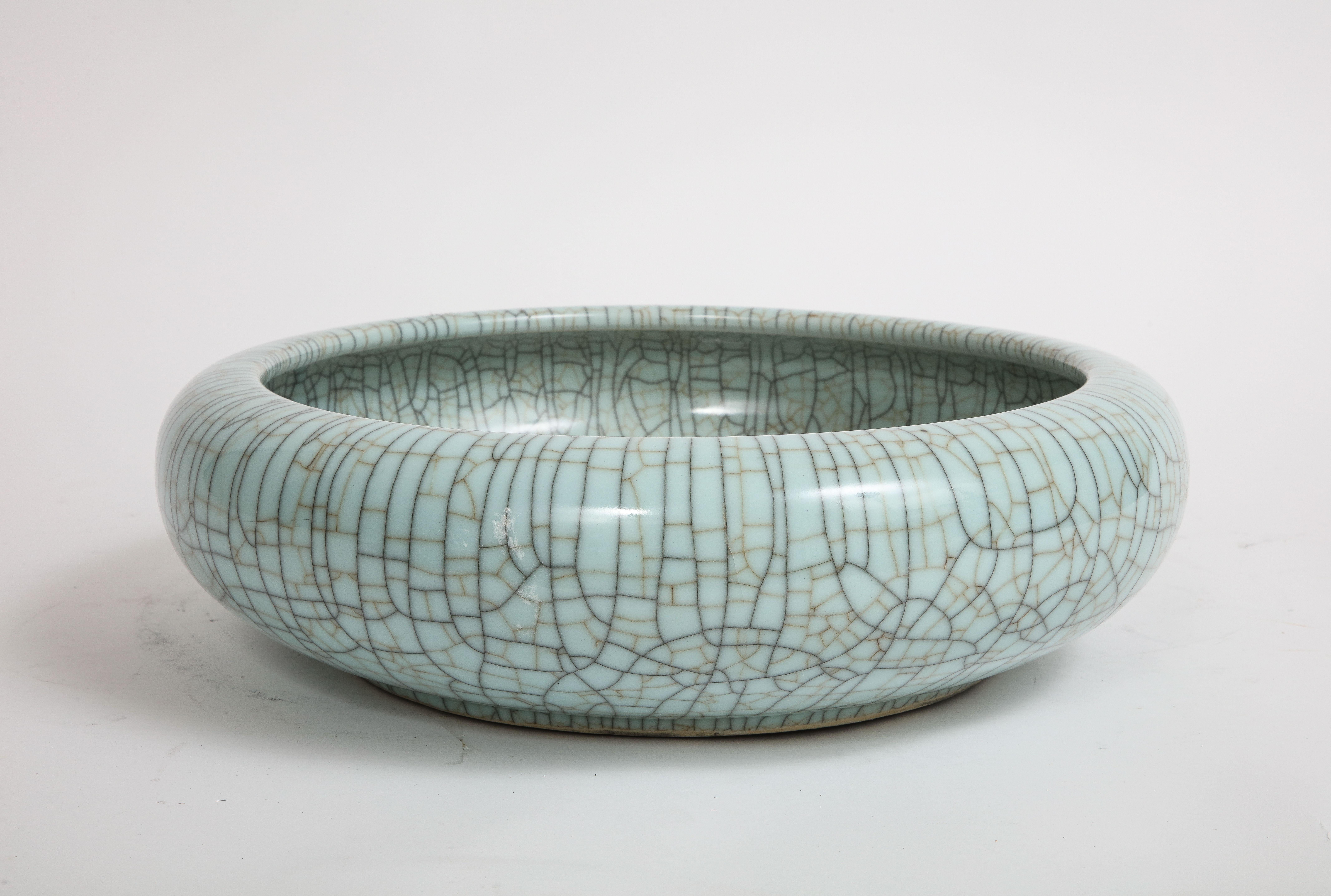 A Fabulous Chinese Celadon Crackle Porcelain Bowl/Centerpiece. This celadon glazed curved edge bowl, hails from the esteemed Qing Dynasty. This remarkable artifact boasts an impressive diameter of 16 inches and enthralls its viewer with its
