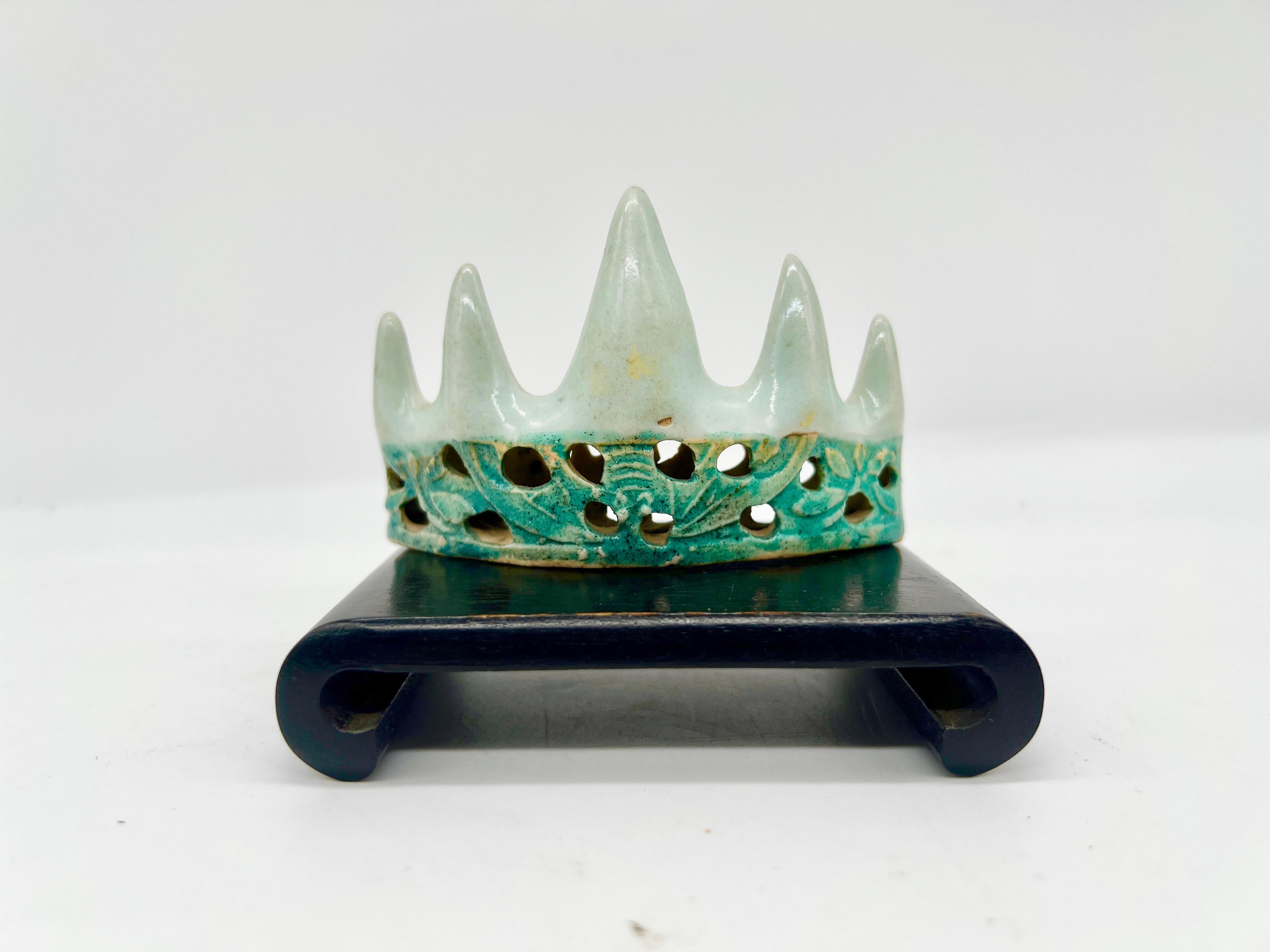 Cet élégant repose-pinceau chinois à glaçure céladon et vert turquoise date de la période Kangxi (1661-1722) de la dynastie Qing, une époque connue pour son exceptionnelle production de porcelaine. Le repose-pinceau, objet essentiel pour les érudits