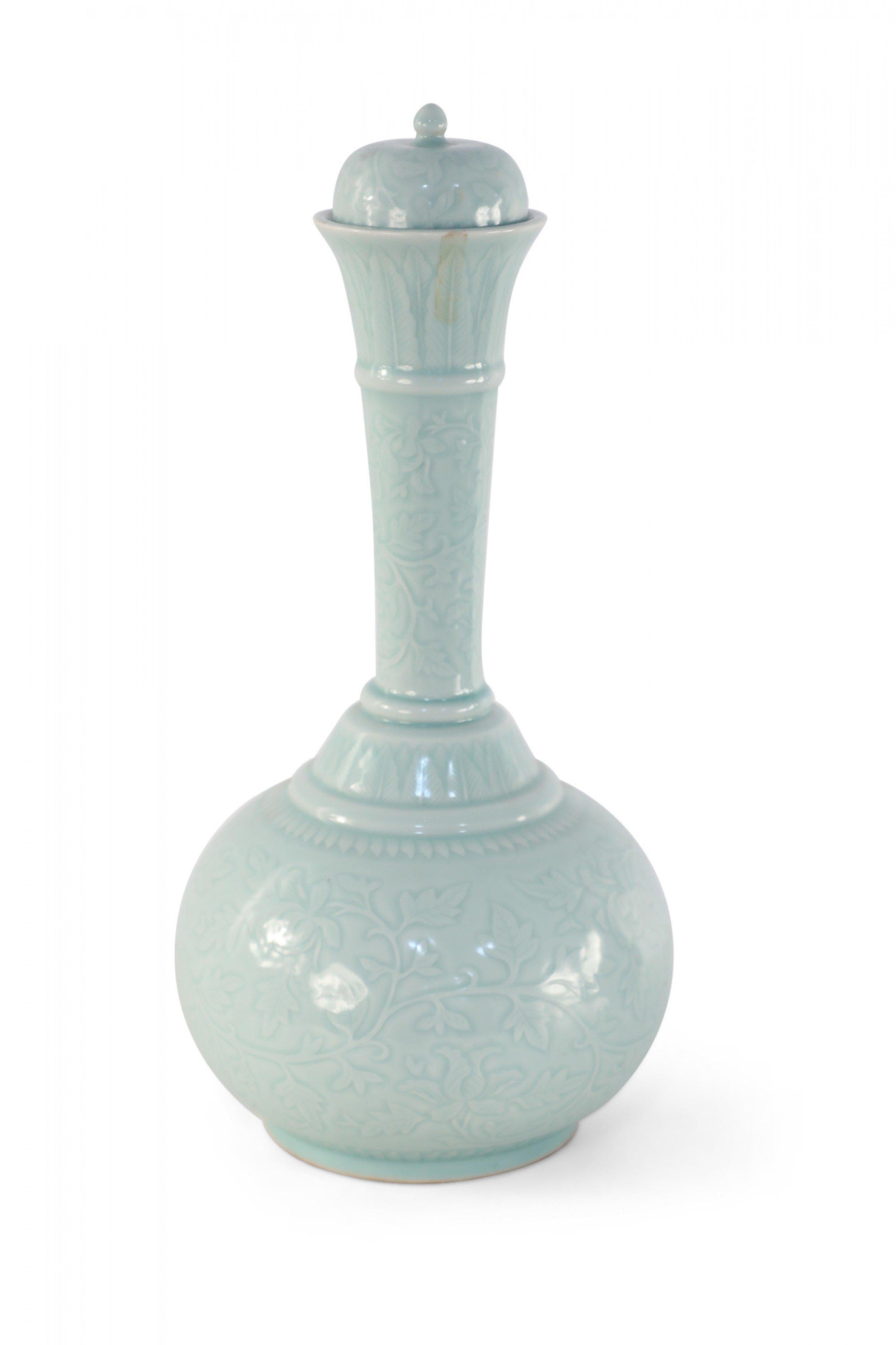 20th Century Chinese celadon ceramic vase with a gourd-shaped form wrapped in a tonal vine pattern and fitted with a ball finial-topped lid. 
  