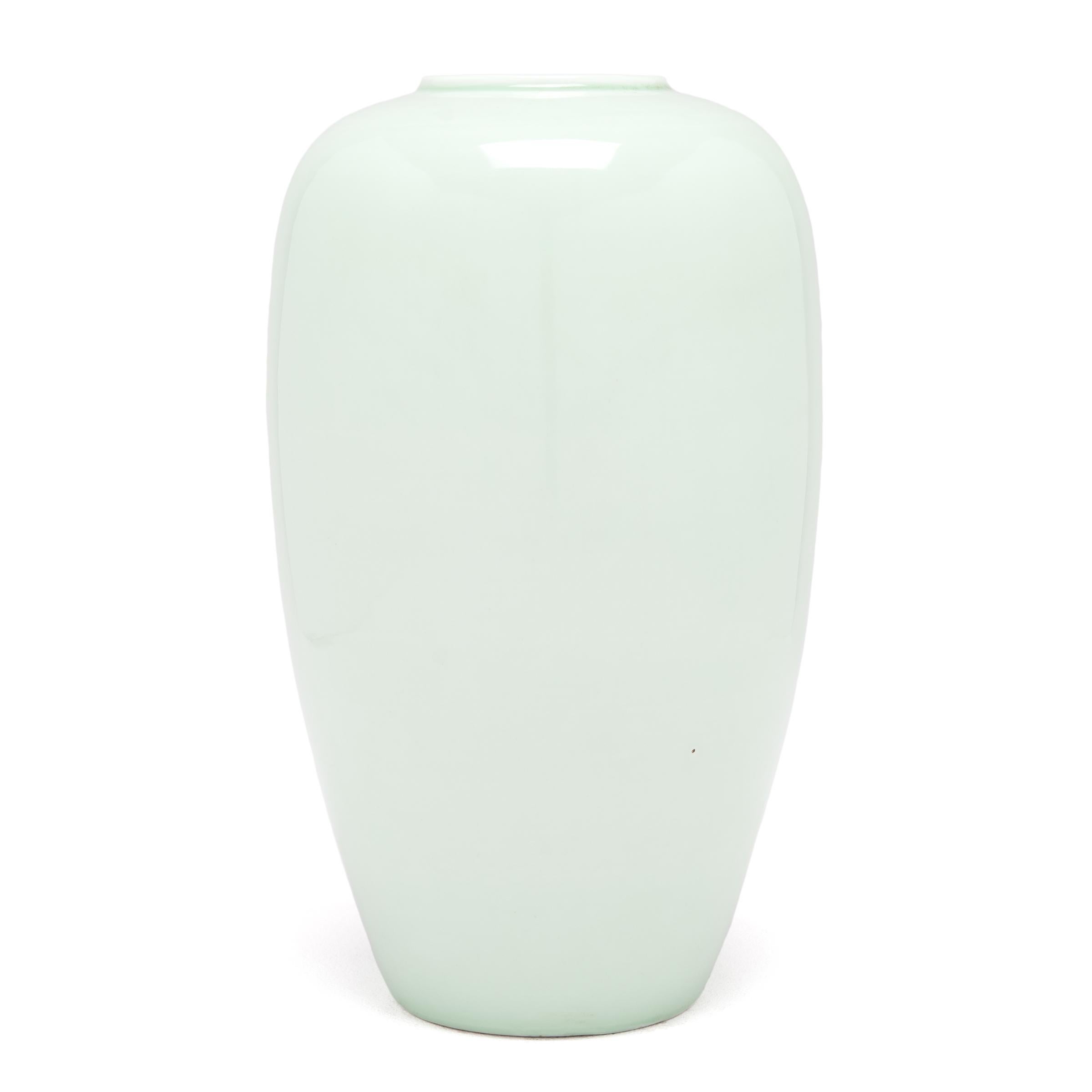 Collectors have coveted Celadon ceramics, like this vase with gentle proportions, for centuries. The glazing process is complex: an artisan covered the vase in liquid iron-rich clay, and then with a glaze that reacts to the iron to create this