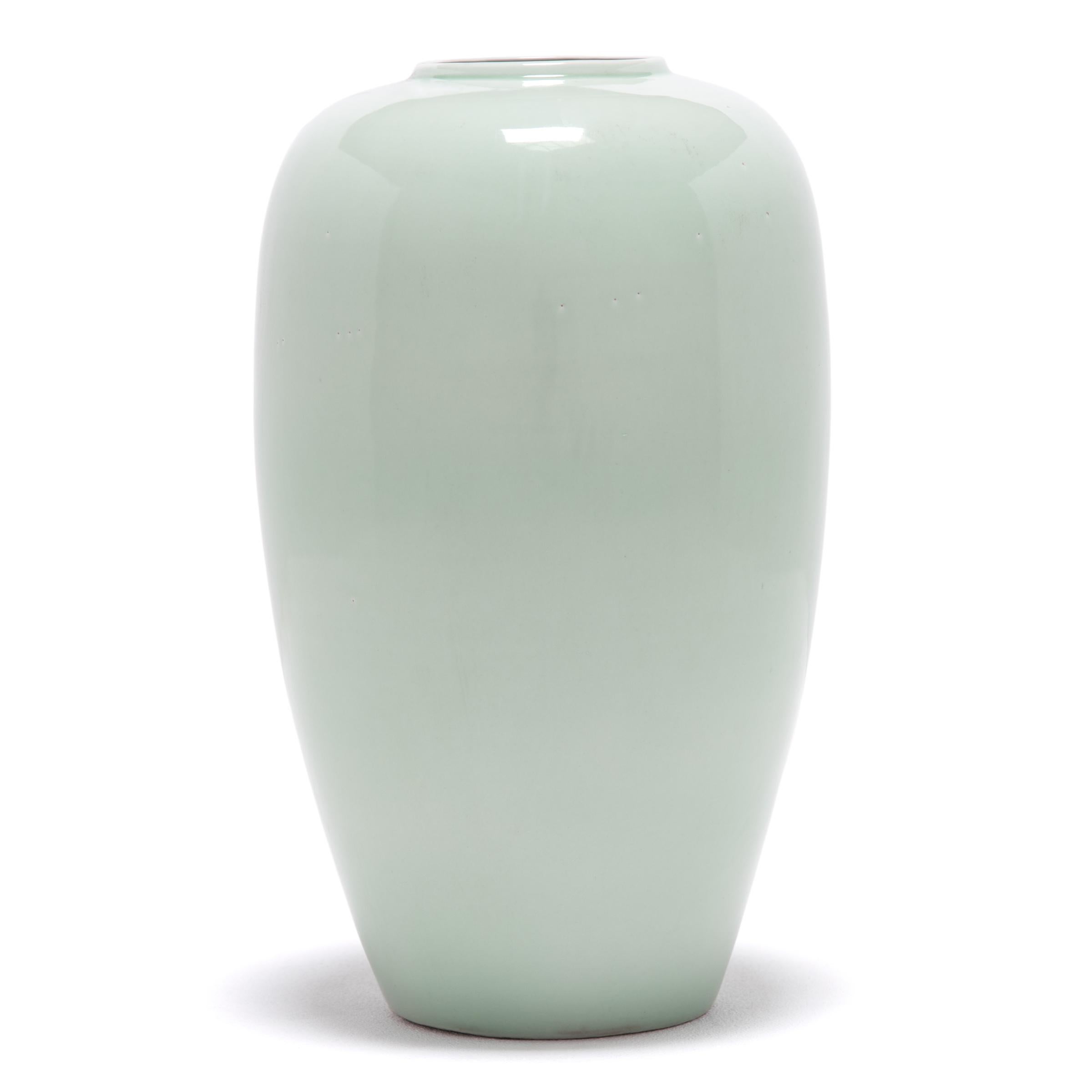 Collectors have coveted celadon ceramics, like this vase with gentle proportions, for centuries. The glazing process is complex: an artisan covered the vase in liquid iron-rich clay, and then with a glaze that reacts to the iron to create this
