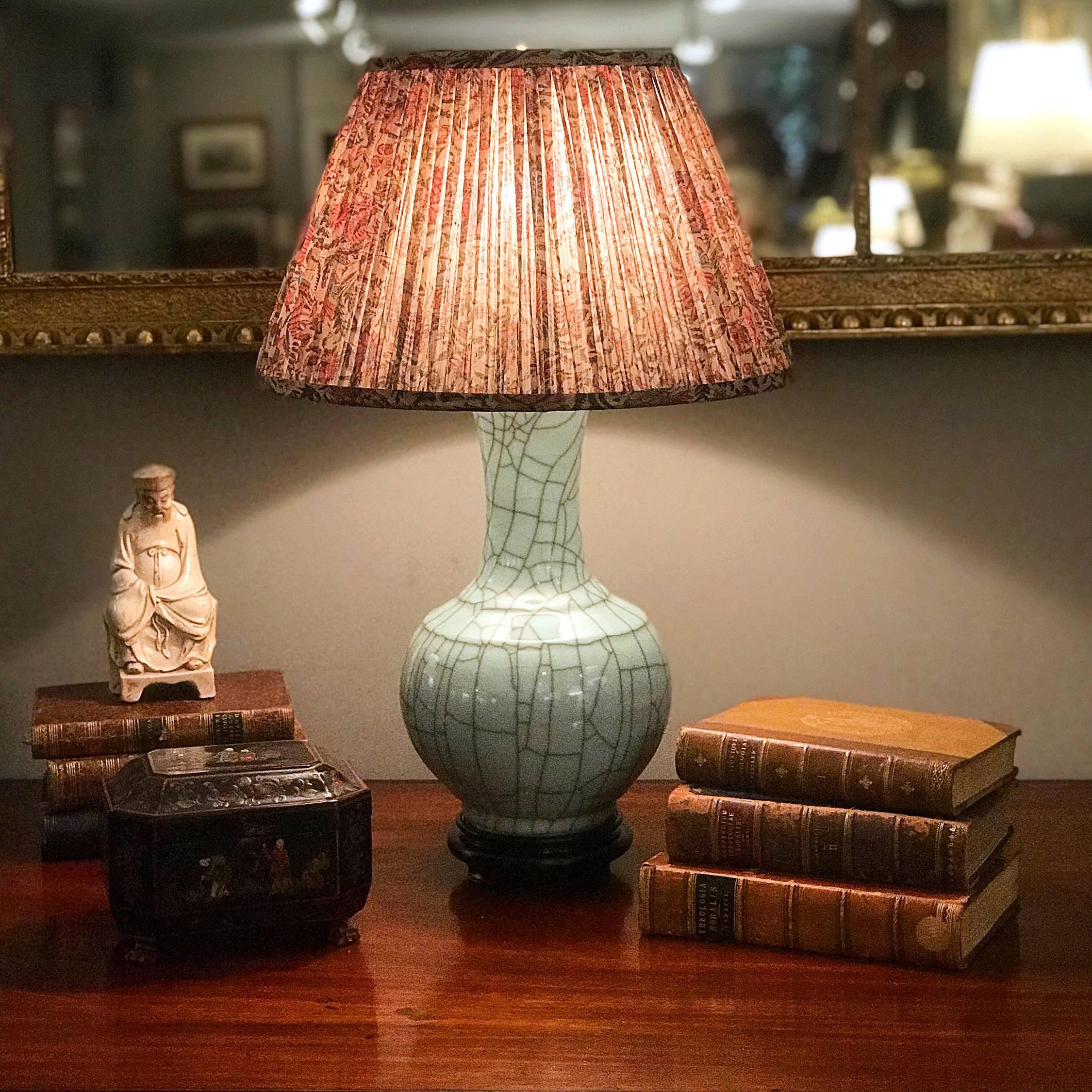 This stunning Chinese porcelain vase, wired as a lamp, is of the tianqiuping or globular form, first popularized during the Ming dynasty, with a striking crackled celadon glaze, the color of green jade. On a molded wooden base with a brass cap and