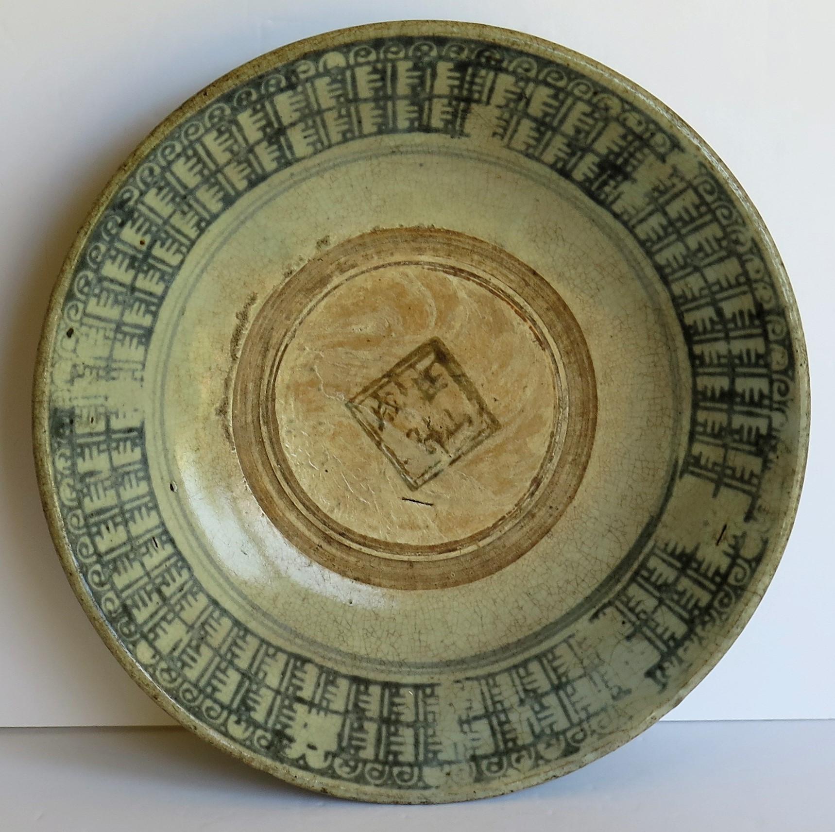 This is a Chinese ceramic bounty plate or bowl, handmade and decorated in cobalt blue which we date to the Ming Period, late 16th century or possibly earlier, back to the 14th century.

The deep plate or bowl is strongly hand potted on a low foot