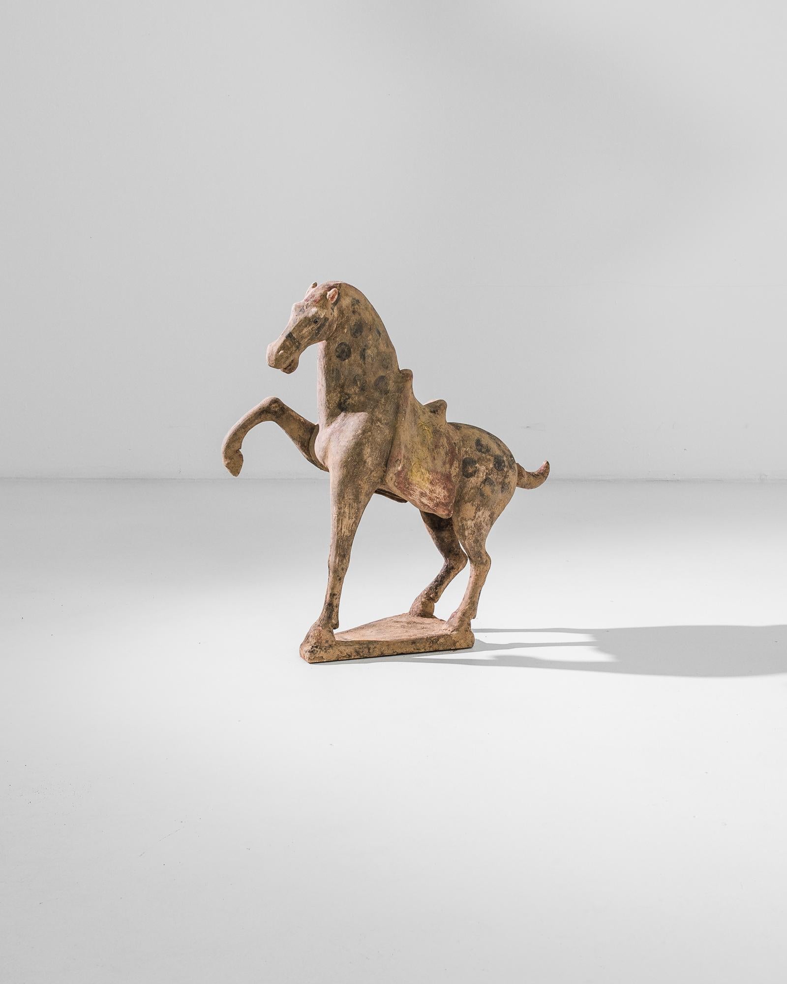 A warm, natural color palette — terra-cotta red and charcoal black — and a textural finish give this jubilant horse a wholesome appeal. The silhouette is simple and harmonious; the kicking front leg is counterbalanced by the spirited up-flick of the