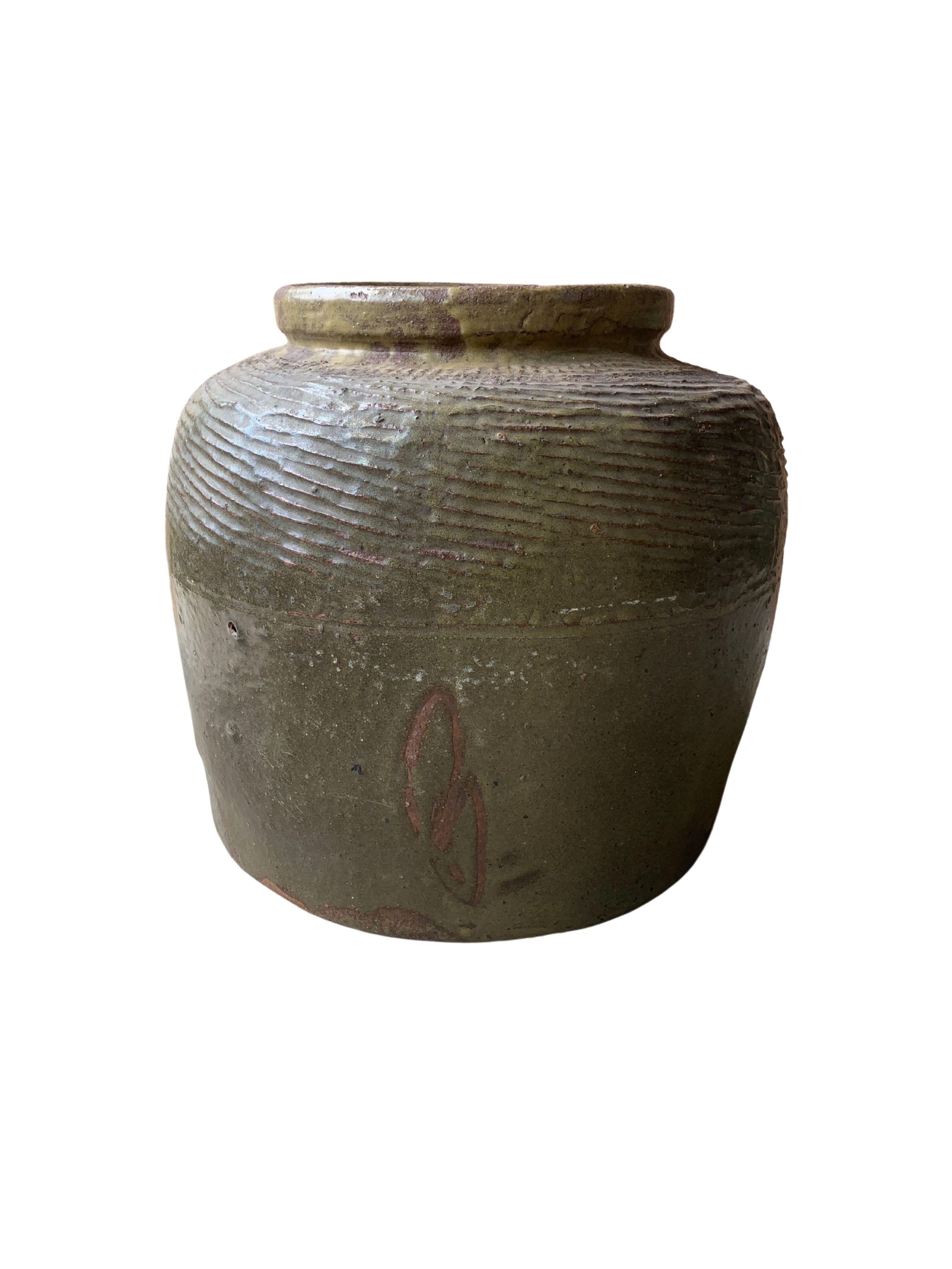 Dieses glasierte chinesische Keramikgefäß wurde früher zum Einlegen von Lebensmitteln verwendet. Es hat eine jadegrüne Oberfläche und eine gerippte Außenseite. Ein großartiges Beispiel für chinesische Keramik, dessen Unvollkommenheit und Alterung im