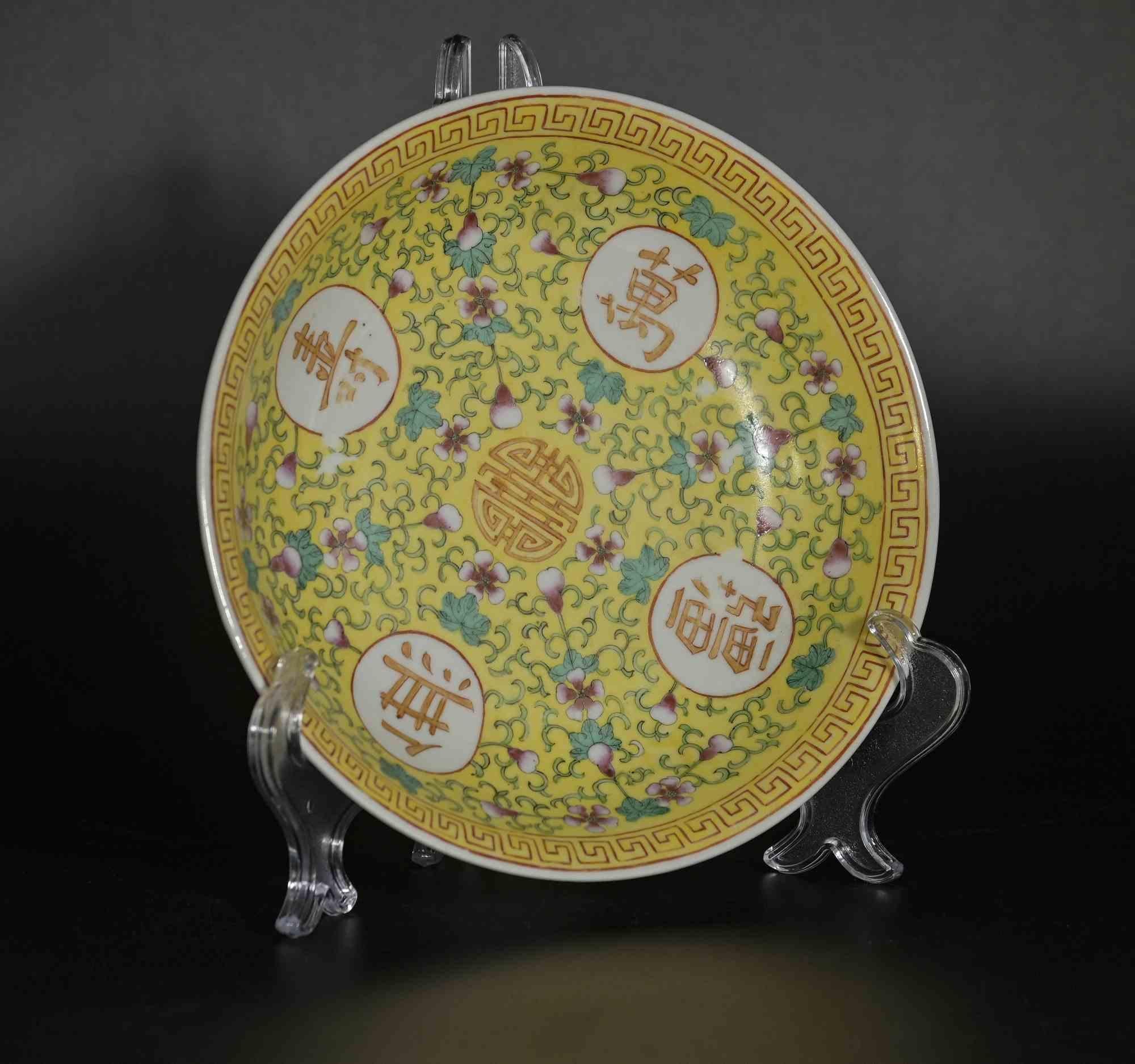 Chinesischer Keramikteller, China 19. Jahrhundert, wahrscheinlich während der Herrschaft von Guangxu in der Qing-Dynastie entstanden.

Florale Motive auf Gelb, mit chinesischer Schrift und Mäandern am Rand. 

Durchmesser der Platte  23 cm.

Gute