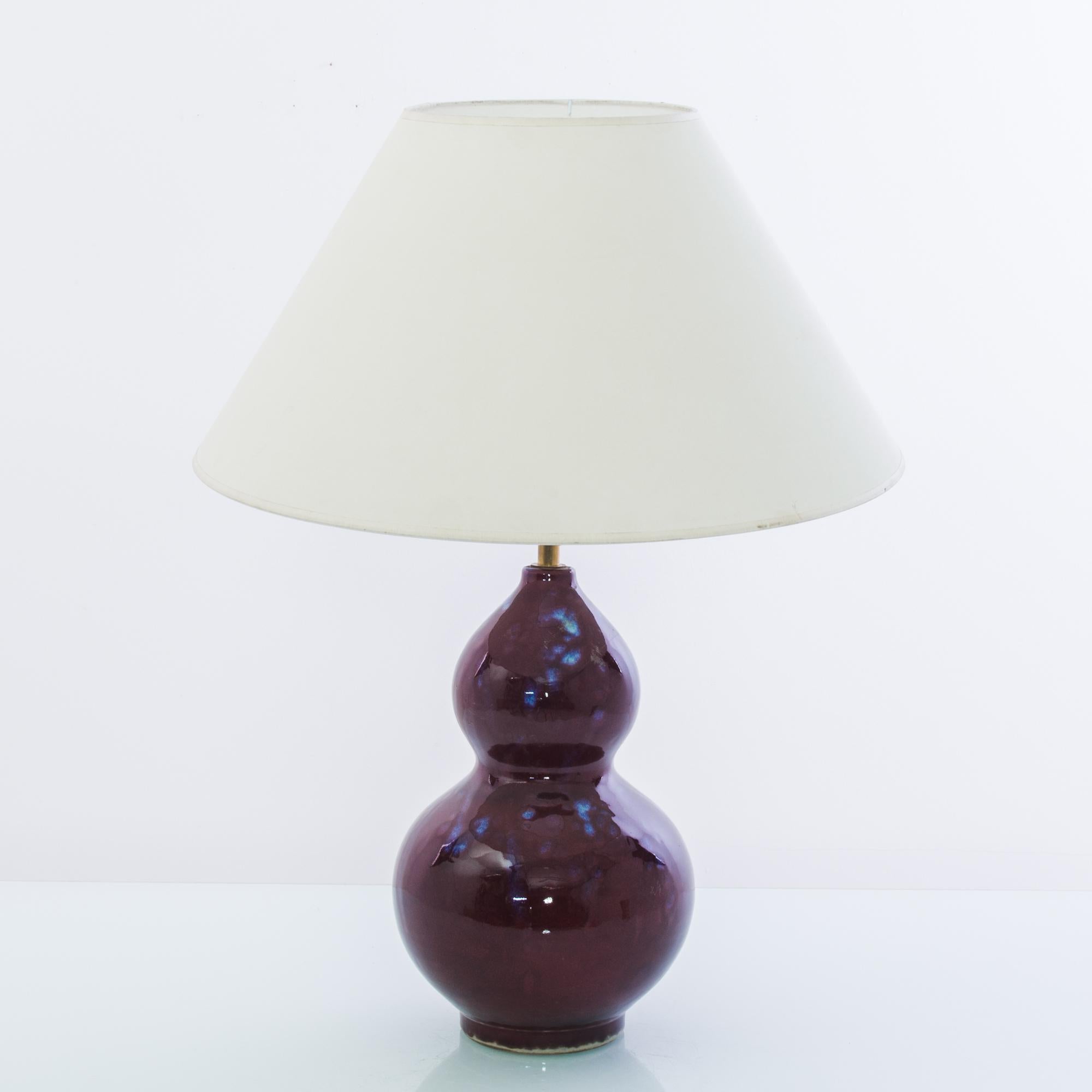 A ceramic table lamp from China. The deep tone and brilliant shine of the plum purple glaze creates a vivid visual impact; patches of brilliant lapis blue add a touch of iridescence. Smooth curves grant a sensuous tactility to the form. Crowned with