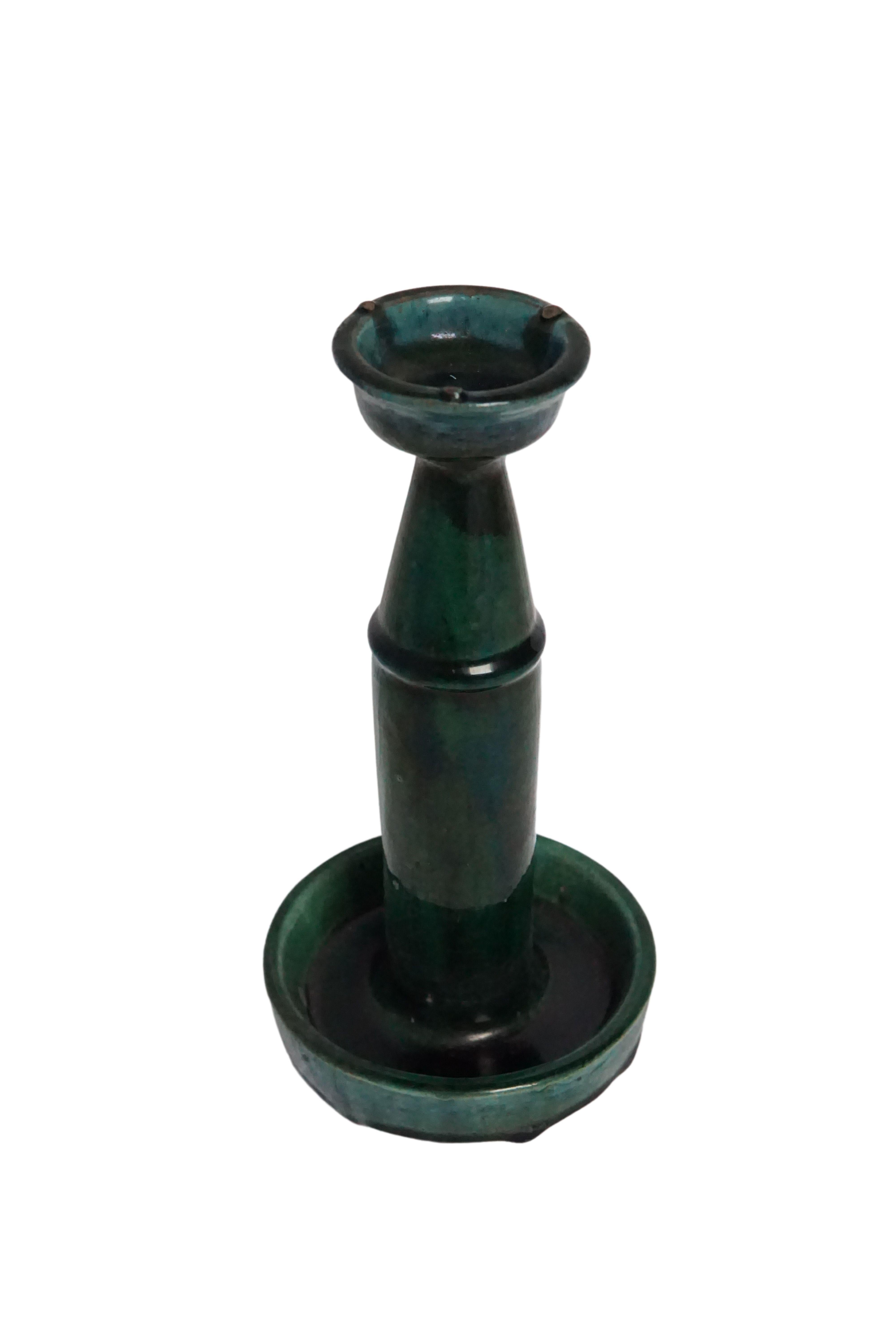 This Shiwan ware oil lamp from the early 20th century features a green glaze. Shiwan ware is a style of Chinese pottery from the Shiwanzhen district near Guangdong, China. A elegant decorative object or candleholder. 

Measures: Diameter 13 cm