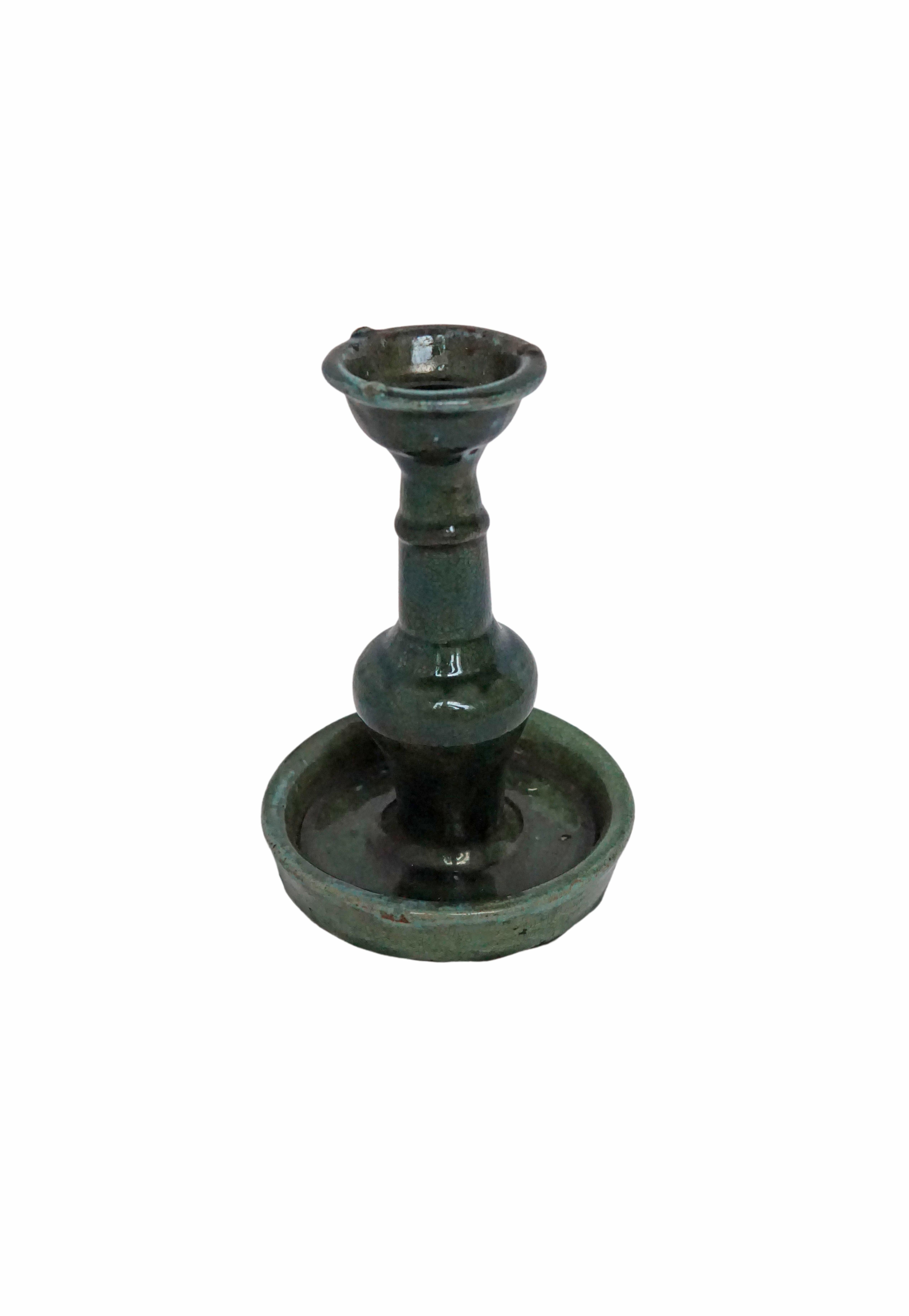 This Shiwan ware oil lamp from the early 20th century features a green glaze. Shiwan ware is a style of Chinese pottery from the Shiwanzhen district near Guangdong, China. A elegant decorative object or candleholder. 

Measures: Diameter 13.5 cm