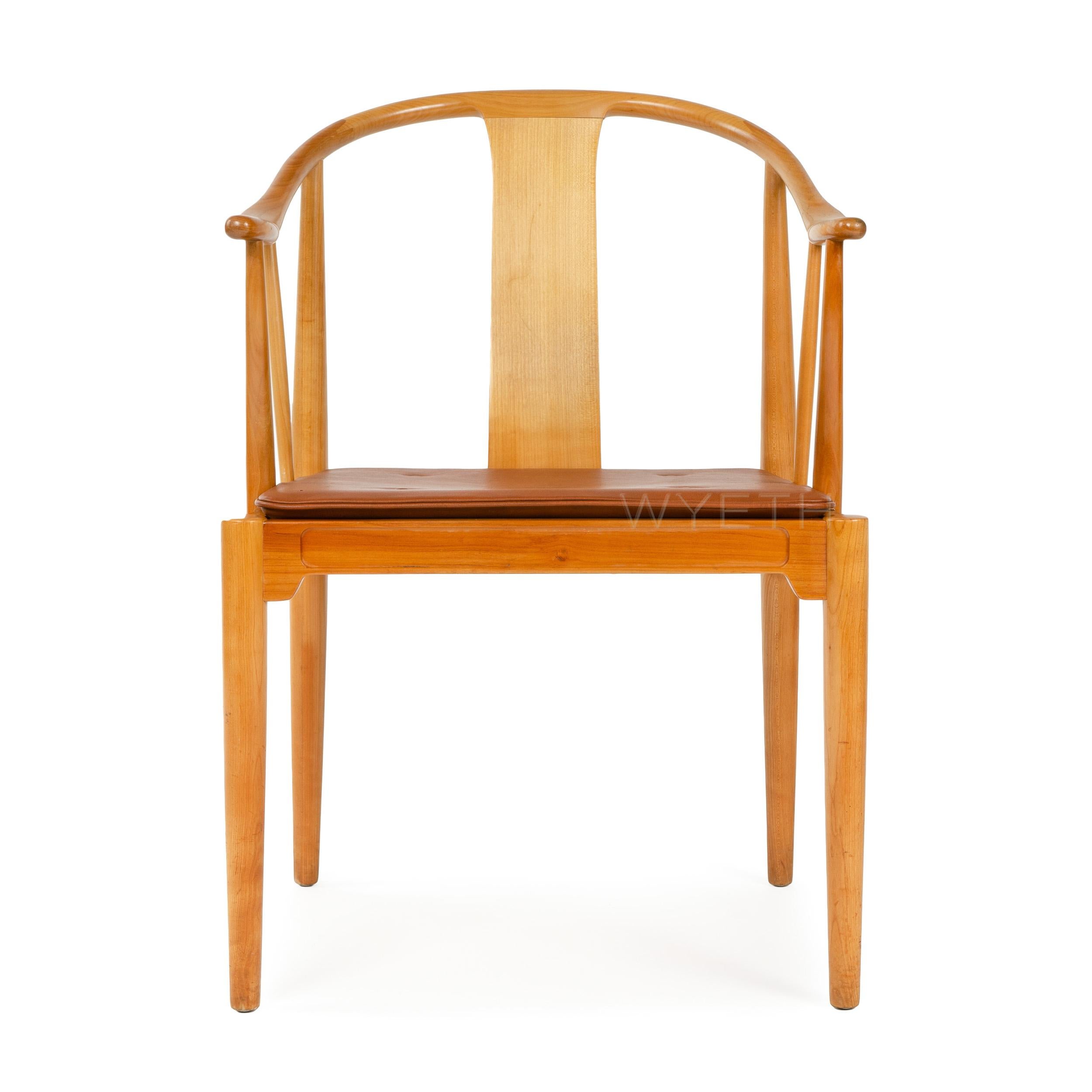 The Chinese Chair designed by Hans Wegner, manufactured by Fritz Hansen. Cherry wood frame featuring a sinuous back and arm design with a natural leather seat cushion. Designed in 1943, crafted in the 1950s in Denmark.