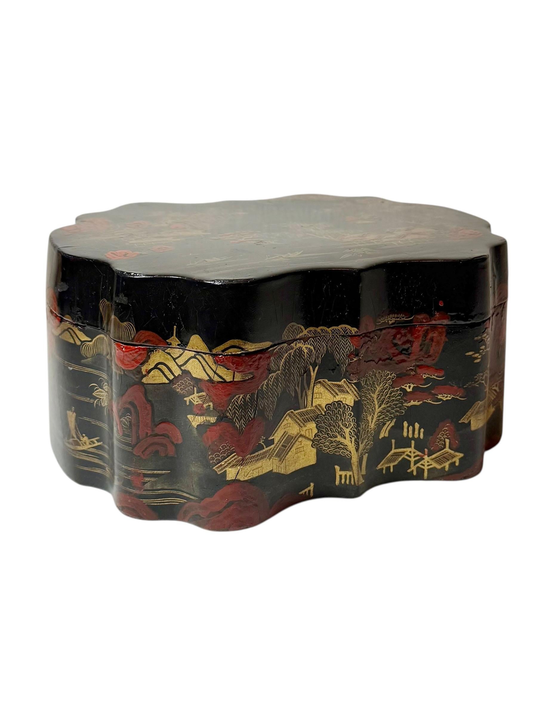 Early nineteenth century Chinese chinoiserie black lacquer box with gold decoration. The exterior shows a finely detailed village scene with houses, trees, and landscape elements painted in gold over a deep black ground with traces of red beneath