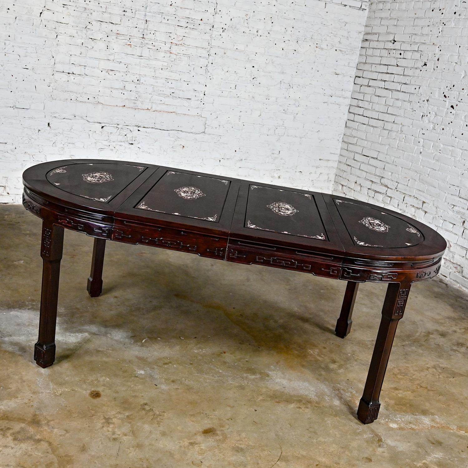 Wonderful vintage Chinese Chinoiserie dining table comprised of Rosewood & Mother of Pearl (m-o-p) round top with 2 leaves, converting it to a small oval with one leaf and large oval with 2 leaves. Beautiful condition, keeping in mind that this is