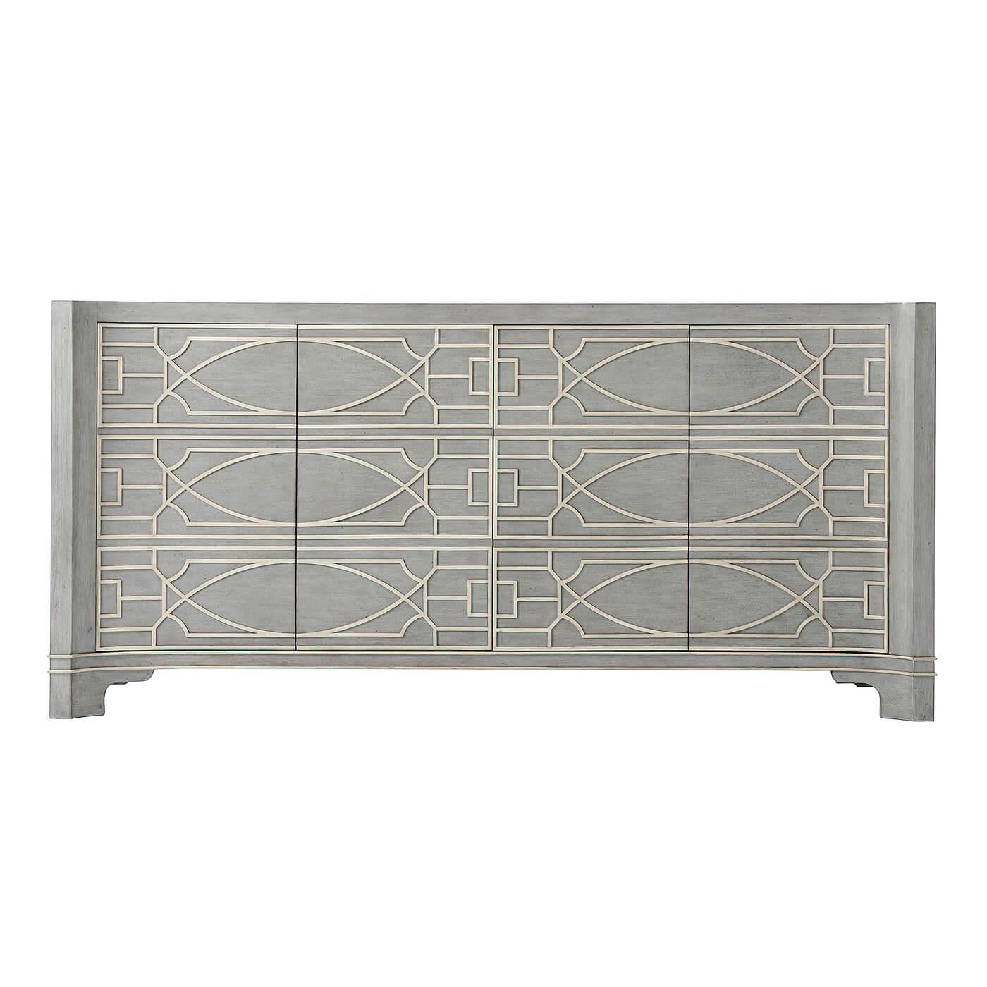 A Chinese Chippendale style long cabinet, with a grey limestone painted finish. A long blind fret design, the antiqued and painted cabinet with four doors and adjustable shelves.

Dimensions: 76.25