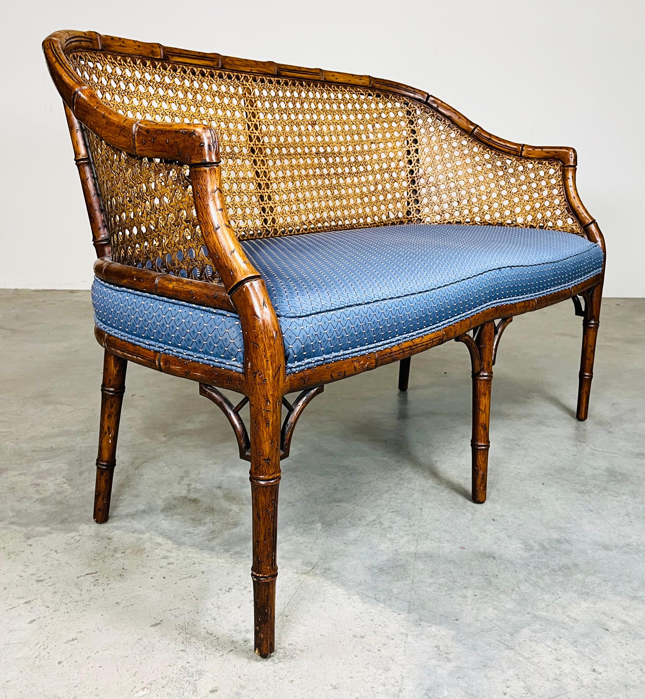 An exquisite Chinese Chippendale style Faux bamboo with caned barrel back settee loveseat upholstered in a deep blue Regency fabric. Circa 1980's.

In very good vintage condition with solid frame and fantastic cane. 

33.25x48.5x25