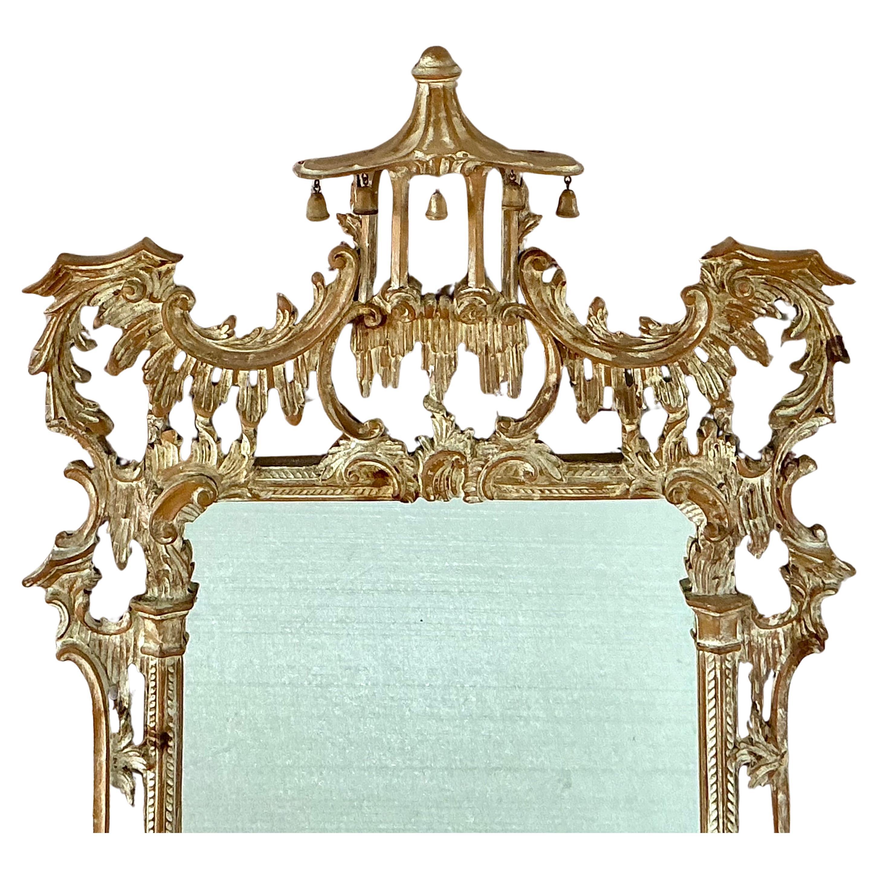 Miroir pagode en bois sculpté de style George III Chippendale. Le miroir a une surface en pin sculptée à la main et présente des feuilles d'acanthe, un sommet en forme de pagode et des cloches. Cette pièce opulente, qui attire le regard, serait un