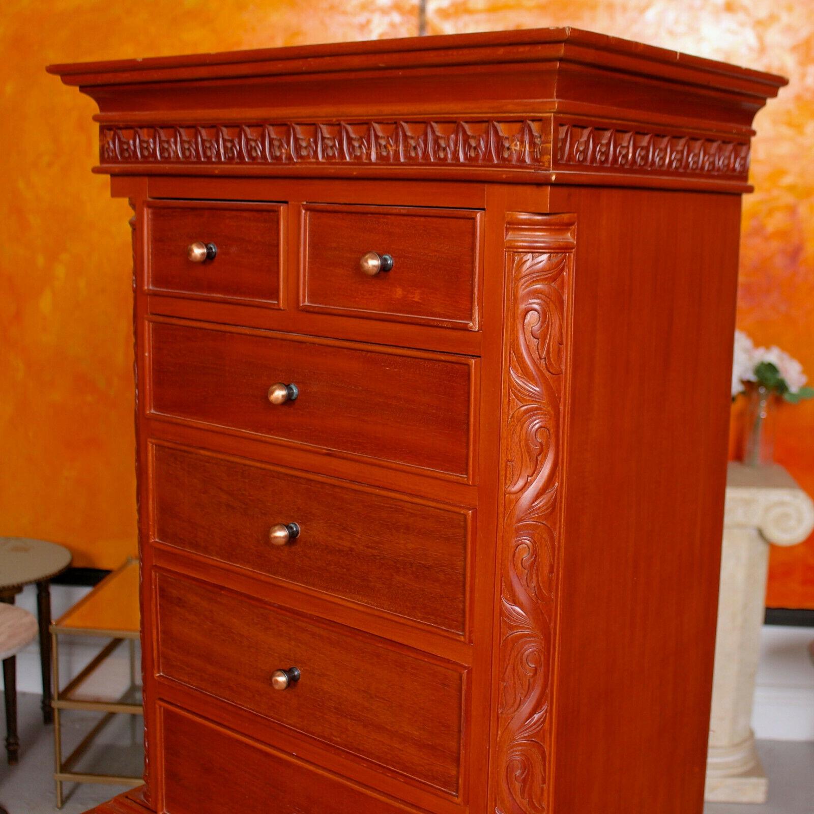 A very pretty 20th century chest on stand with Chinese and Chippendale influences.

The projecting cornice above an acanthus carved frieze and arrangement of two short over four
graduated long drawers flanked by canted angles. The lower section