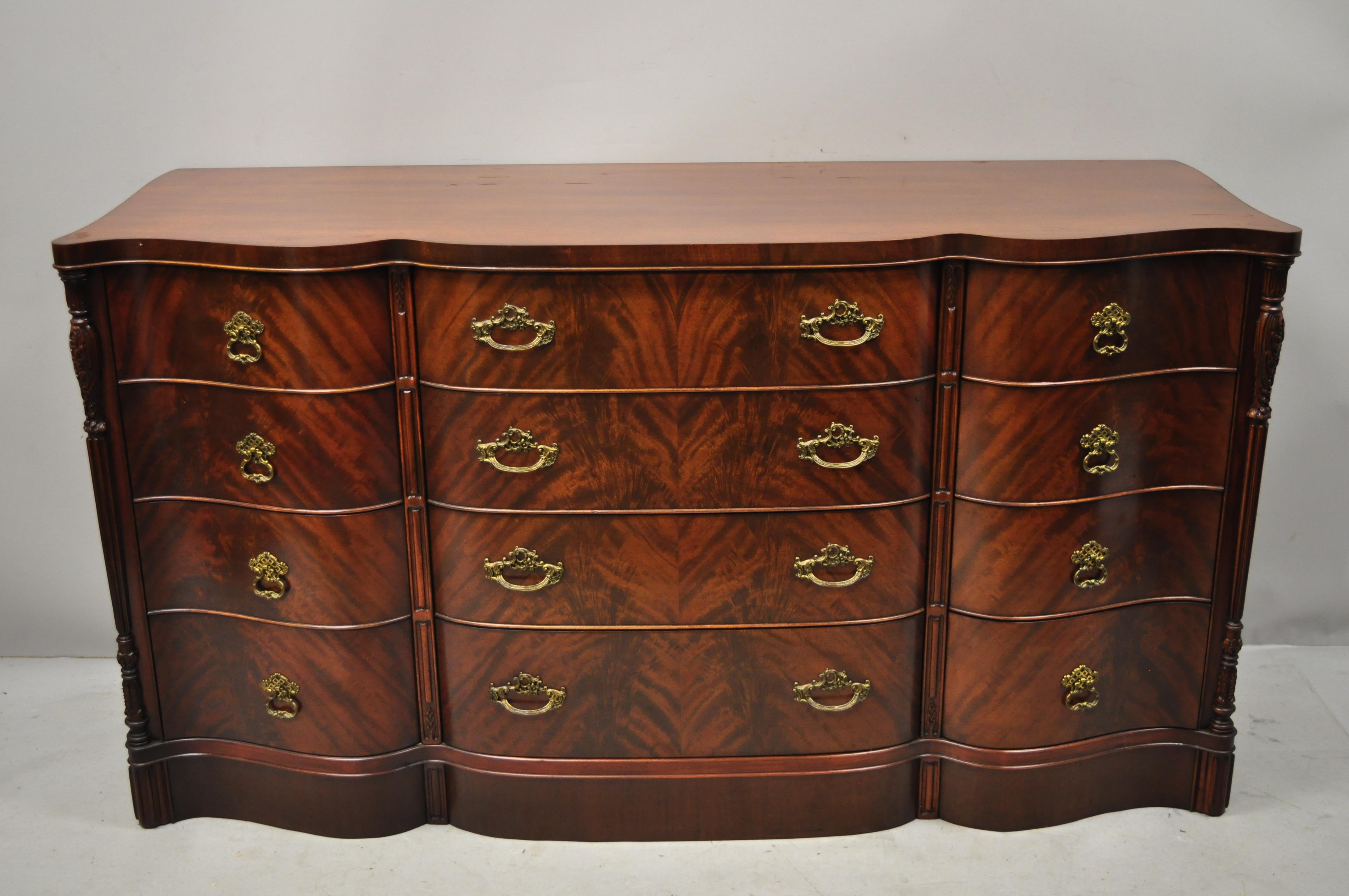 Chinese Chippendale crotch flame mahogany serpentine front dresser with carved pagoda mirror. Item features custom glass top, serpentine front, beautiful wood grain, 12 dovetailed drawers, solid brass hardware, quality american craftsmanship, great