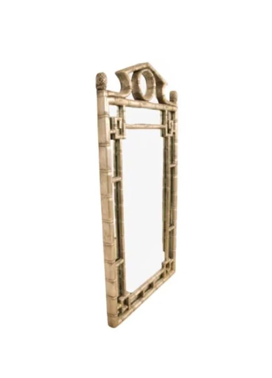 Questo splendido specchio cinese in stile Chippendale incarna il perfetto mix di eleganza esotica e raffinatezza classica. Realizzato con una struttura in finto bambù, il pezzo mostra la distintiva influenza Chippendale, caratterizzata da dettagli