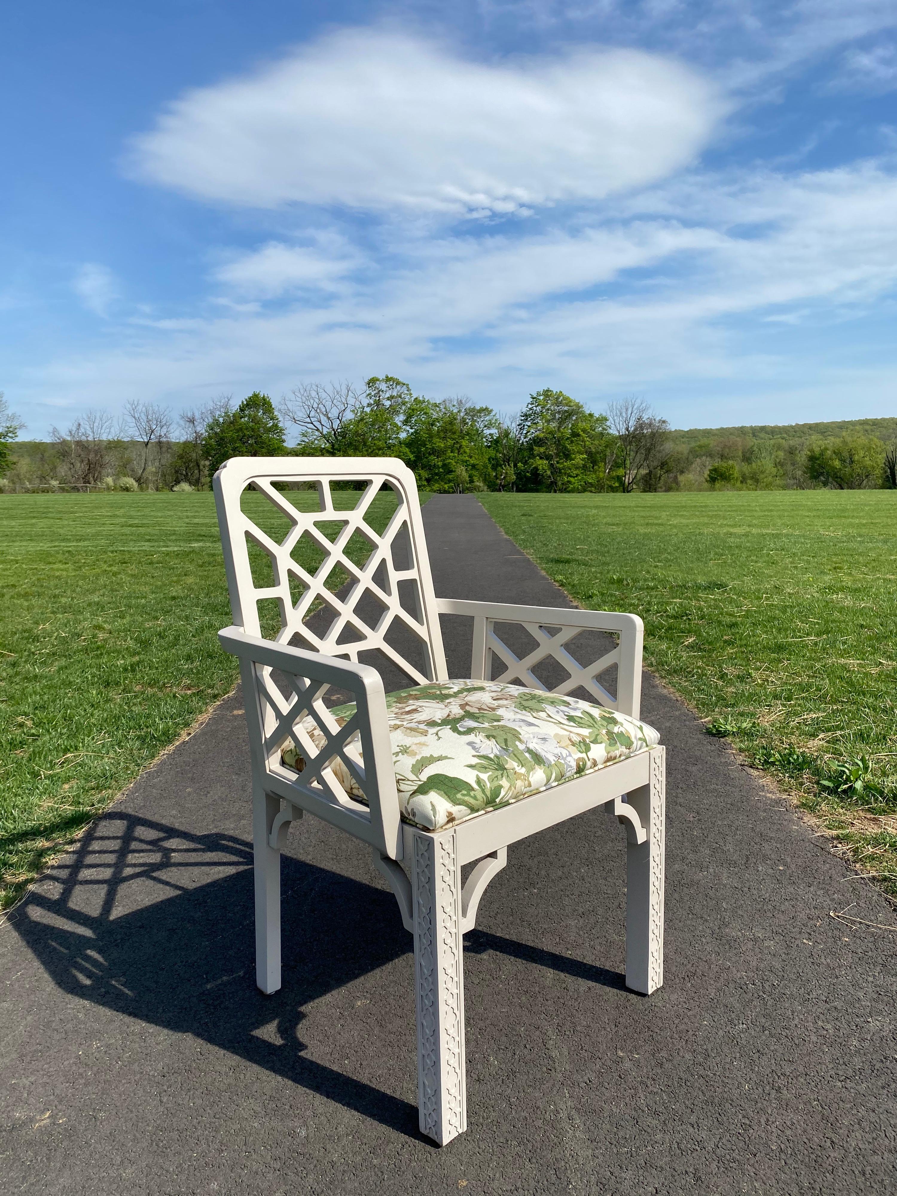 Graphic Chinese Chippendale style armchair with carved fretwork detailing. This vintage Hollywood Regency style chair is painted a neutral grey/cream tone and has been professionally upholstered in Parish-Hadley's iconic Maisie 100% Linen botanical