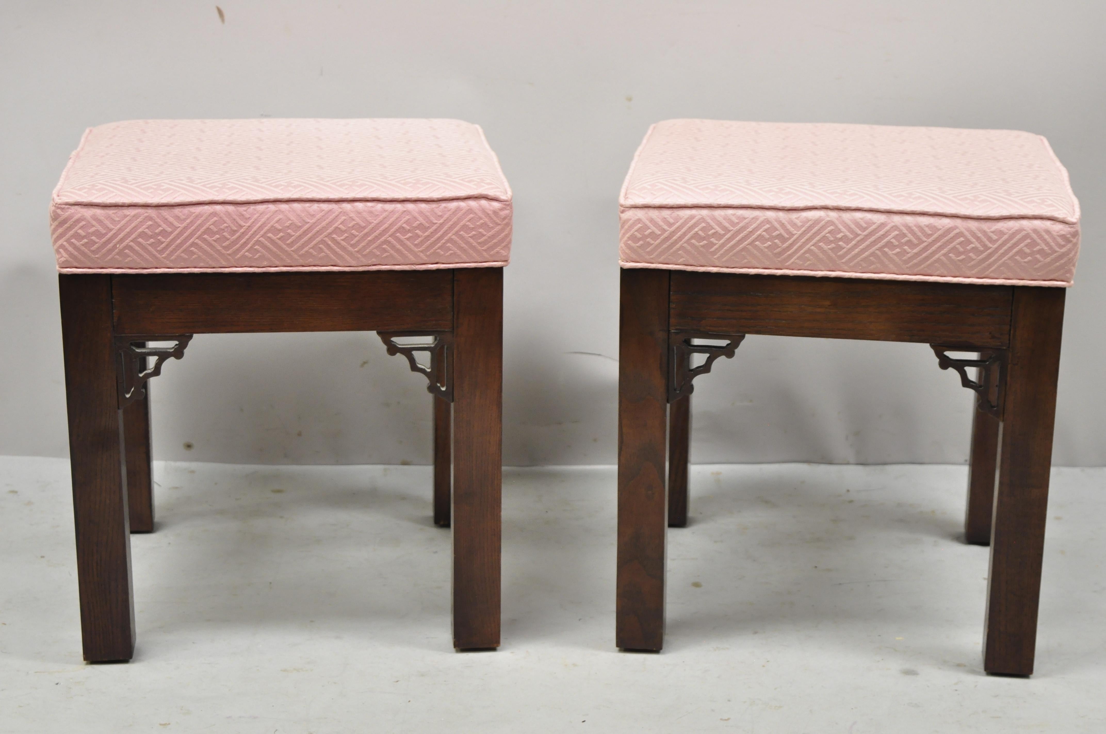 Vintage Chinese chippendale carved fretwork square pink upholstered stools ottoman - a pair. Item features pink upholstered square box seat, carved fretwork corners, solid wood construction, very nice vintage pair, quality American craftsmanship,