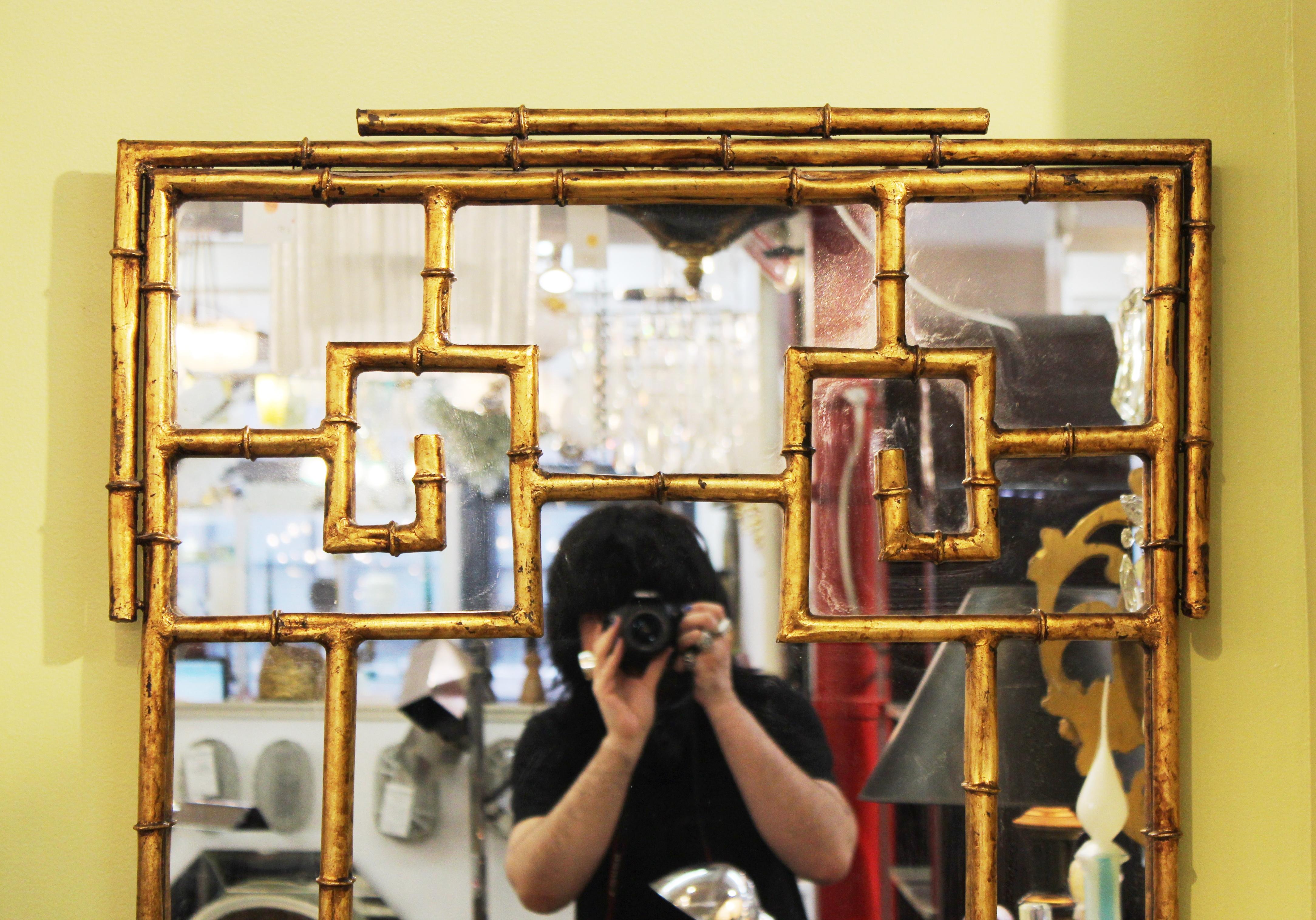Chinese Chippendale gilt metal faux bamboo wall mirror, made during the 1970's. In great vintage condition with age-appropriate wear and use.