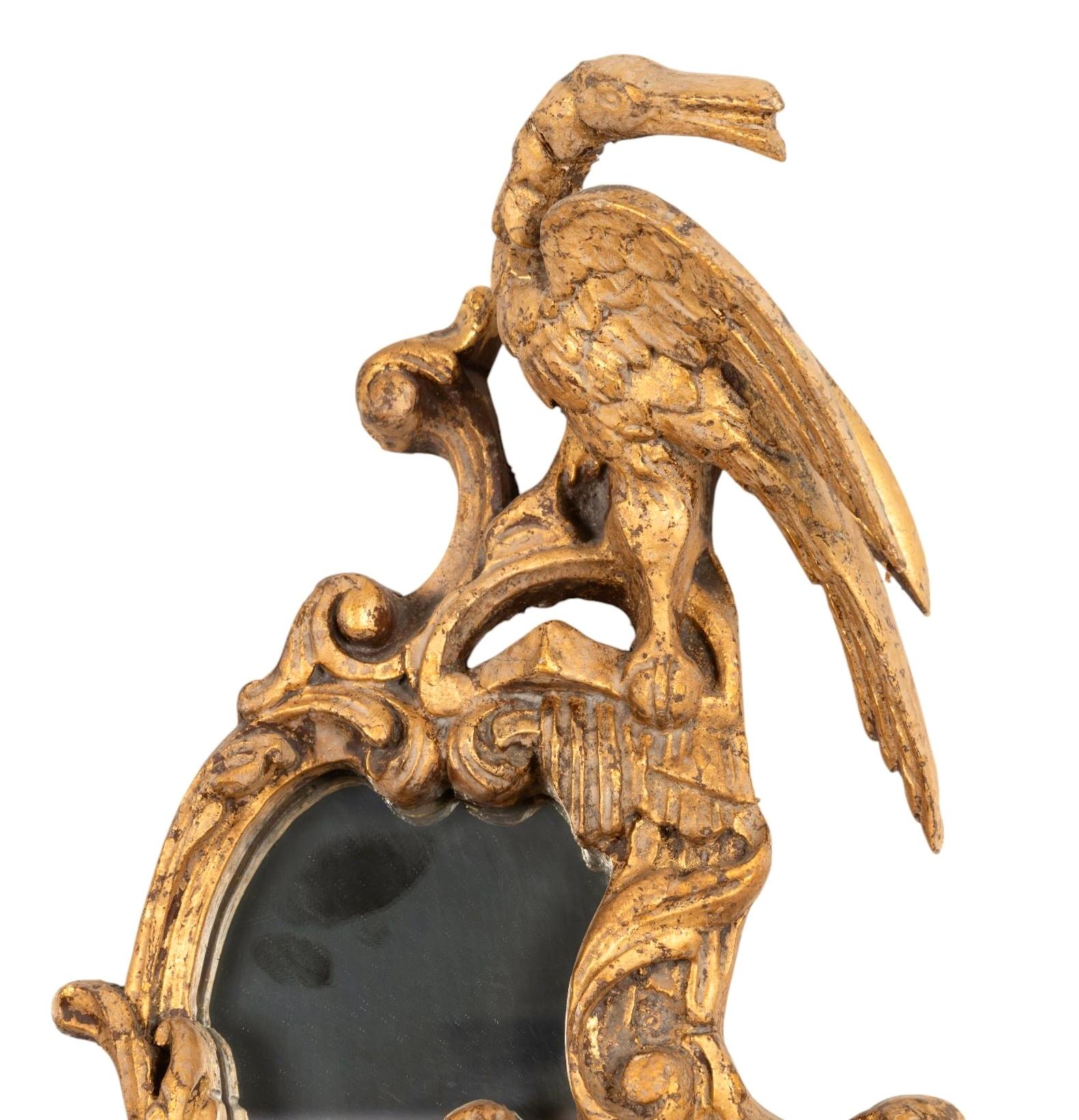 Coppia di specchi in legno dorato in stile George III dell'inizio del XX secolo. La piastra dello specchio si trova all'interno di una cornice a cartiglio asimmetrica intagliata e modellata alla maniera rococò di Thomas Chippendale. Gli specchi