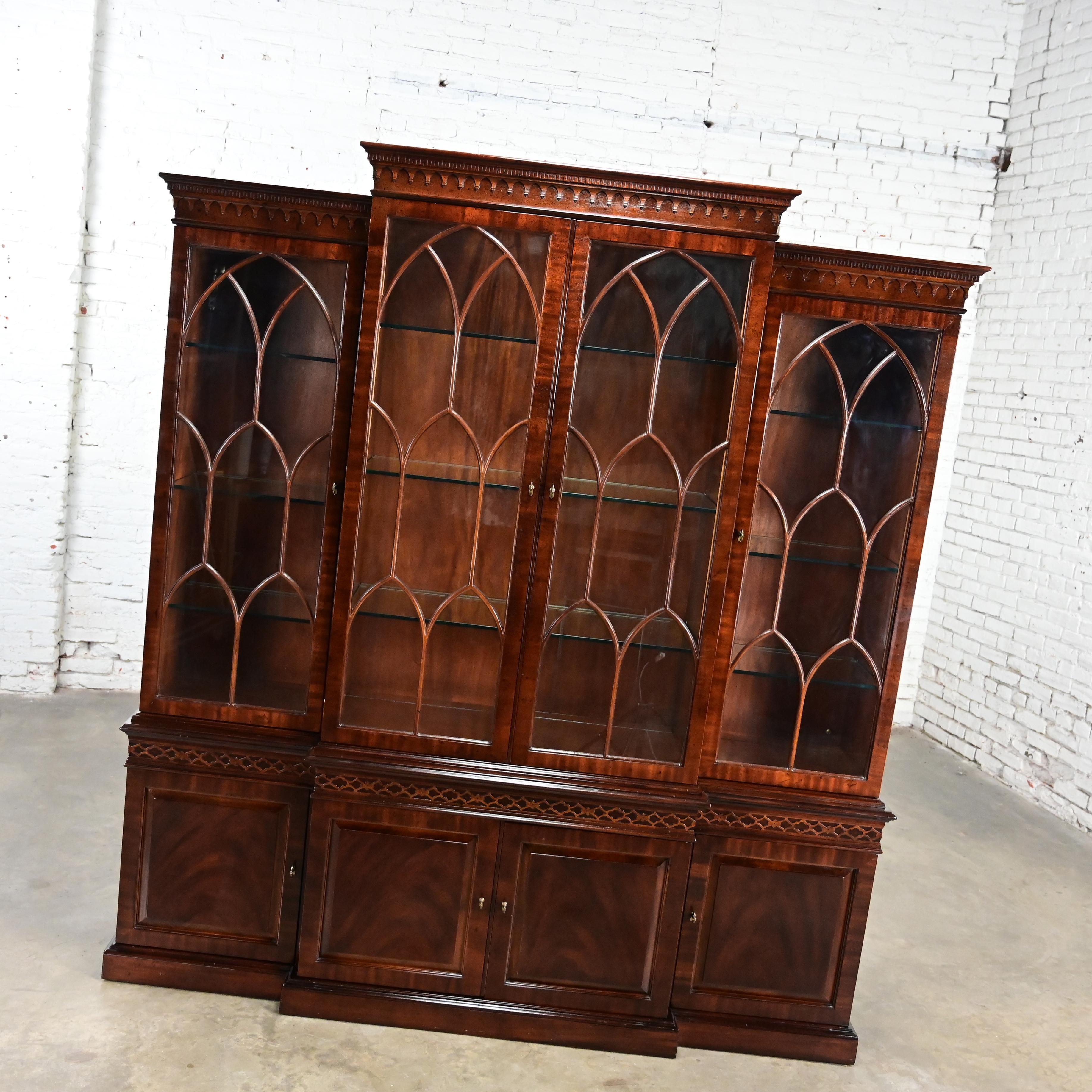 Gorgeous vintage Chinese Chippendale Henredon 2 piece mahogany finished hardwood Breakfront lighted display cabinet with glass door fronts with decorative mullions, glass shelves with plate grooves and a lower section with 3 center drawers and a