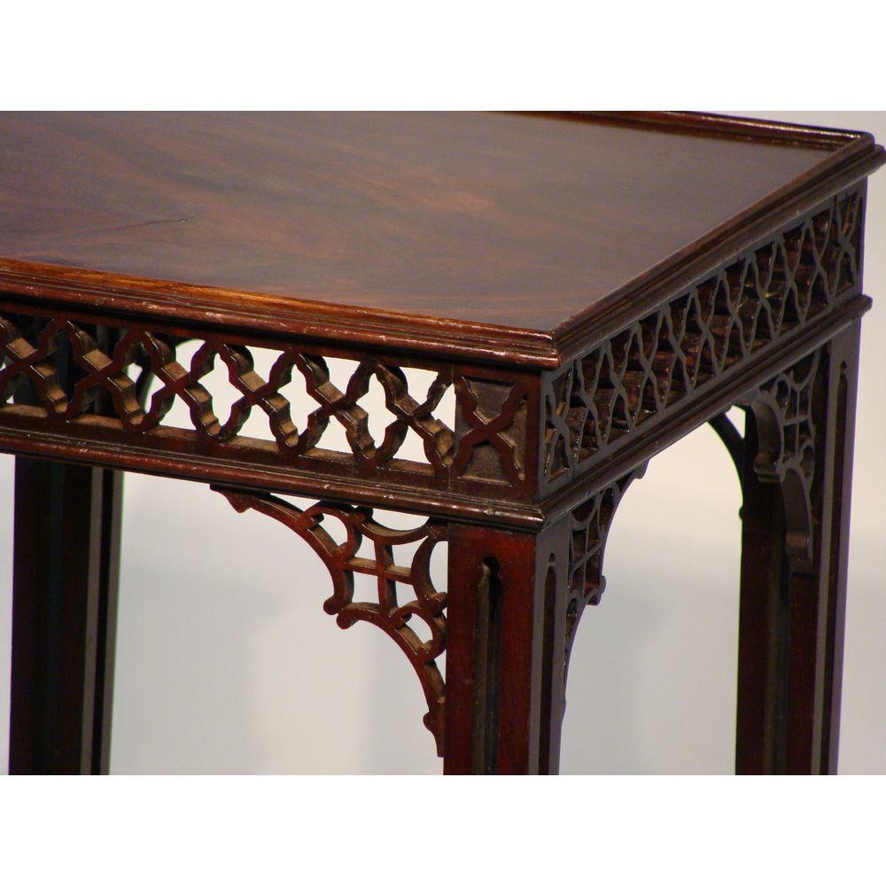 The square top of this late 18th century 'Chinese' Chippendale style mahogany kettle/ urn stand is of very good color, and bordered with a simple beaded edge.

The frieze finely carved with open fretwork. The angles similarly set with open