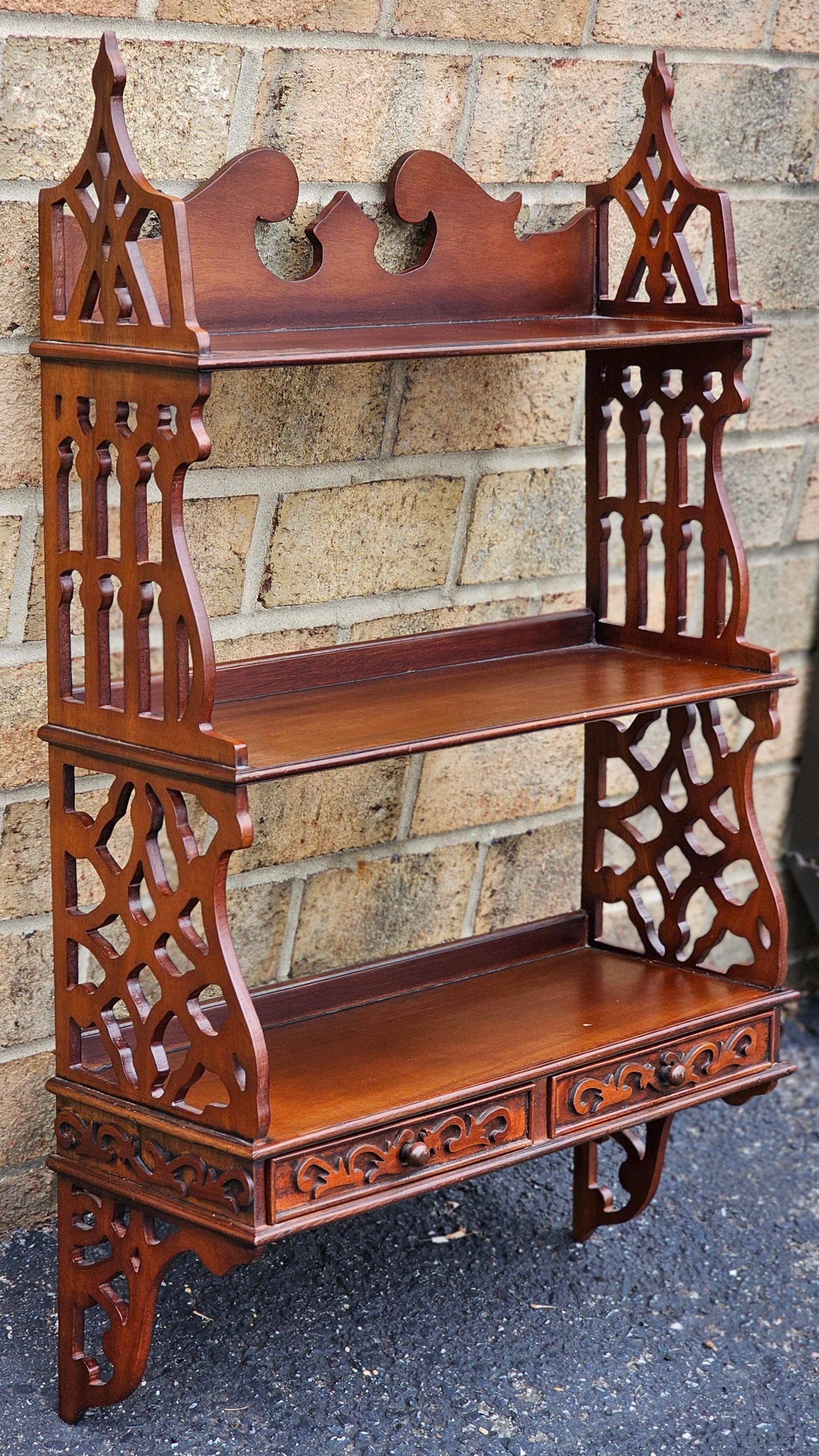 A cute  Chinese Chippendale Mahogany Two Drawer Hanging Wall Shelf. 
Very Attractive and functional. Three shelves between open fret work sides for convenient and elegant organization and display. Eco-friendly plantation-grown mahogany
Measures