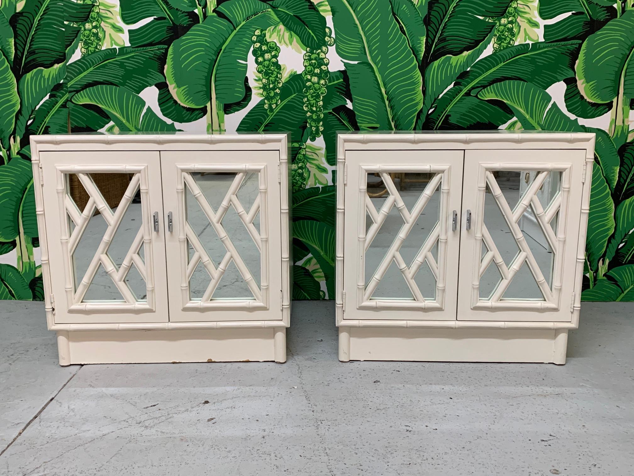 Pair of Hollywood Regency style nightstands feature chinoiserie pattern detailing over mirrored doors. Good condition with minor imperfections consistent with age.