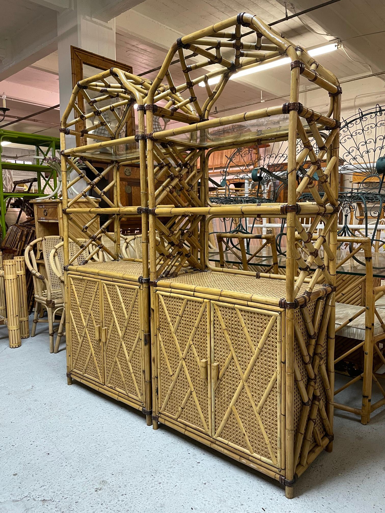 Pair of large rattan etageres feature Chinese chippendale fretwork and cane veneered shelves. Beautiful chinoiserie style pagoda tops and glass shelving. One unit has a large open 2-space storage area behind double doors, the other has 3 drawers.