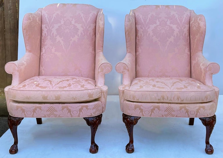 These chairs are Chinese chippendale style ball and claw wingback chairs by Hickory Chair. The blush colored damask does show some age wear. They are marked and in otherwise very good condition.