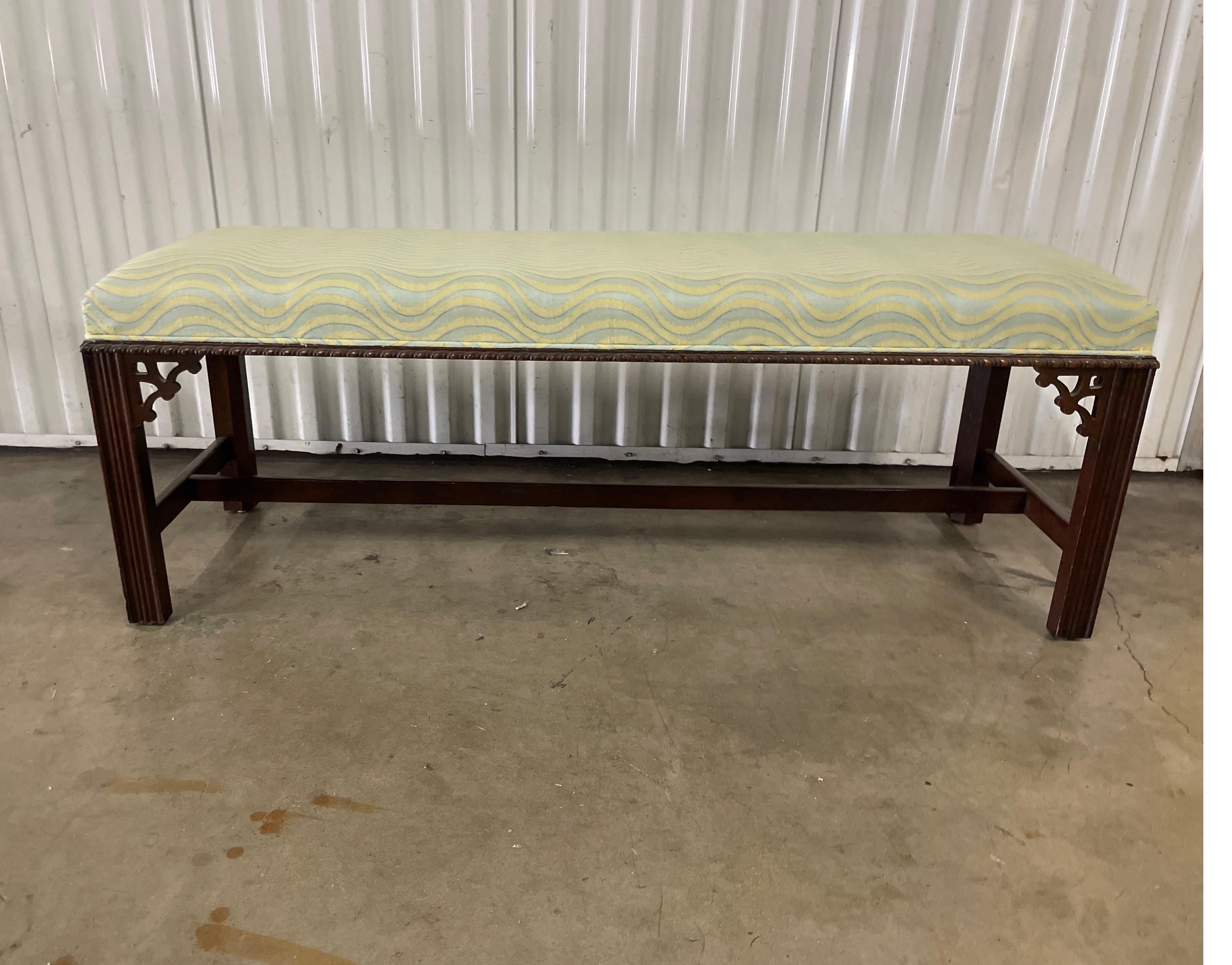 Chinese Chippendale style upholstered bench. Very nice detail around the top cushion and fretwork in all four corners. Fabric has a wave design. Very simple, yet elegant.