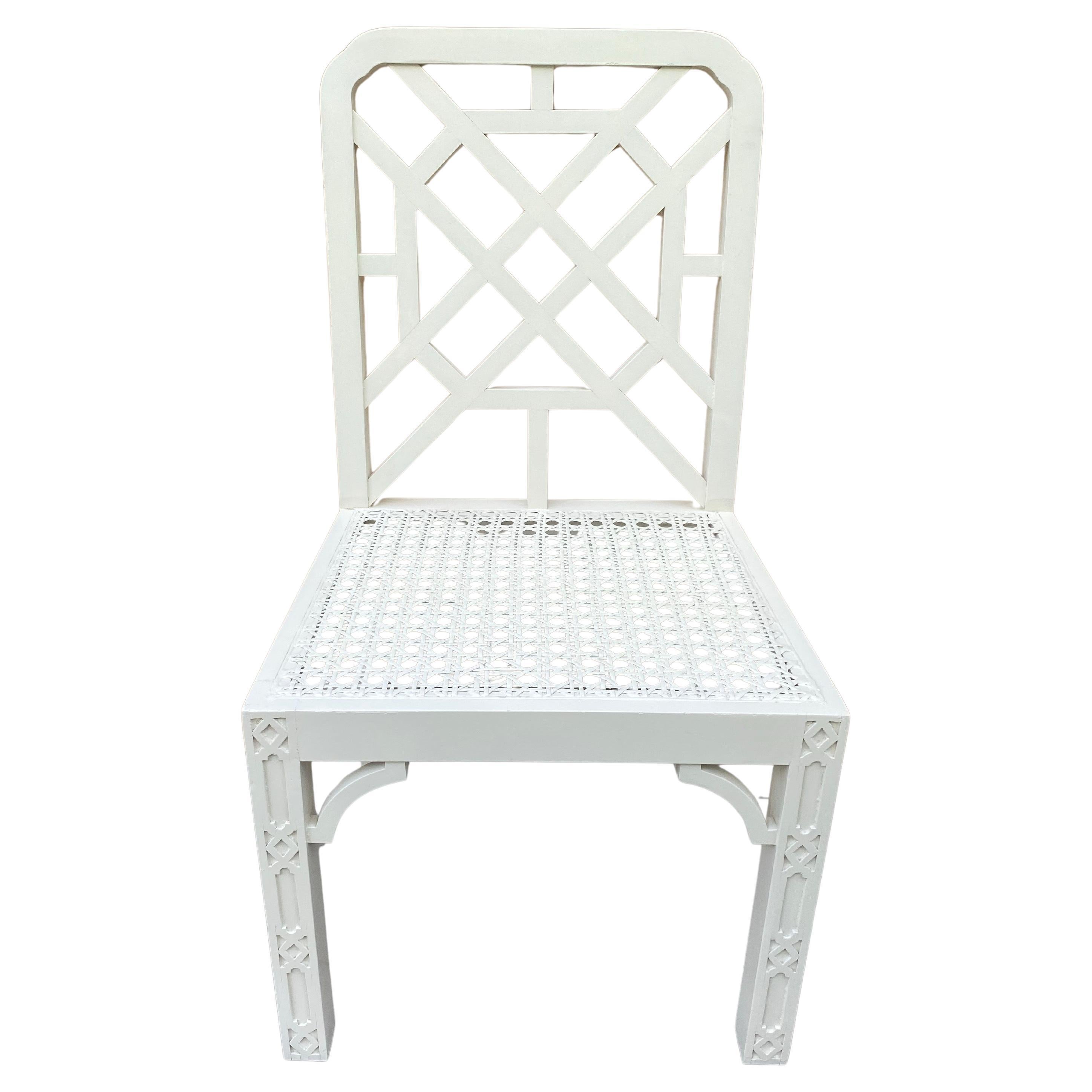 Poltrona cinese in legno intagliato in stile Chippendale con seduta in canna intrecciata.  Questa poltrona neutra dipinta di crema presenta uno splendido schienale a traliccio traforato e intricati dettagli a traforo sulle gambe anteriori.  Questa