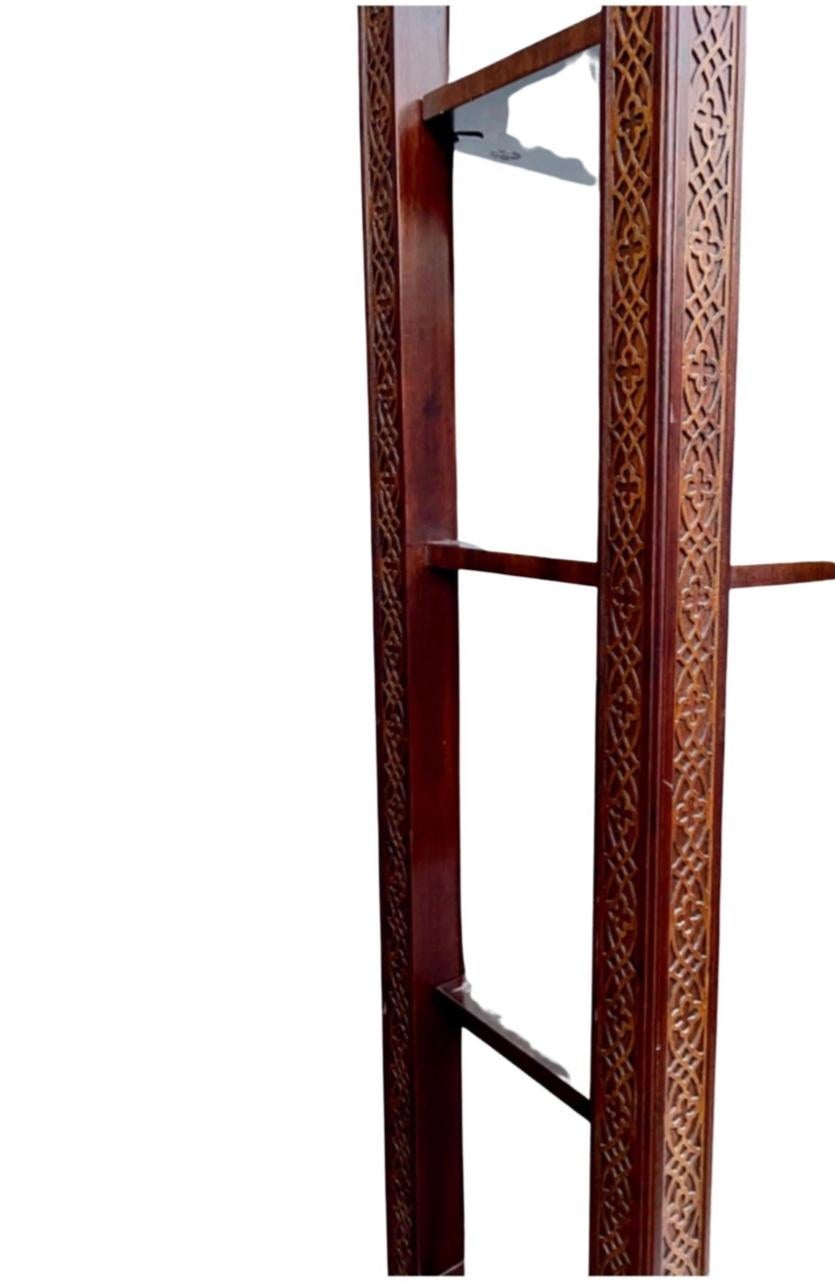 This is a very nicely carved pair of Chinese Chippendale style carved mahogany etagere or bookcase. Carved all around with fretwork running down the frame. Three of the shelves are fixed, and the others are adjustable. 
The listing is for the pair.