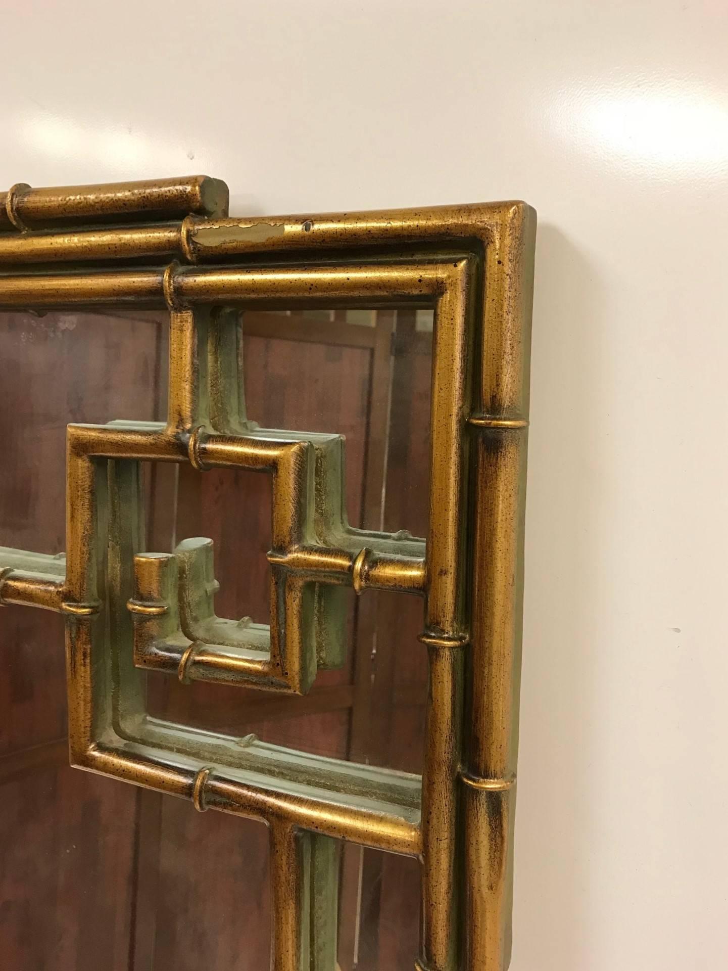 Chinese Chippendale style faux bamboo mirror. Frame is resin with a gold finish.