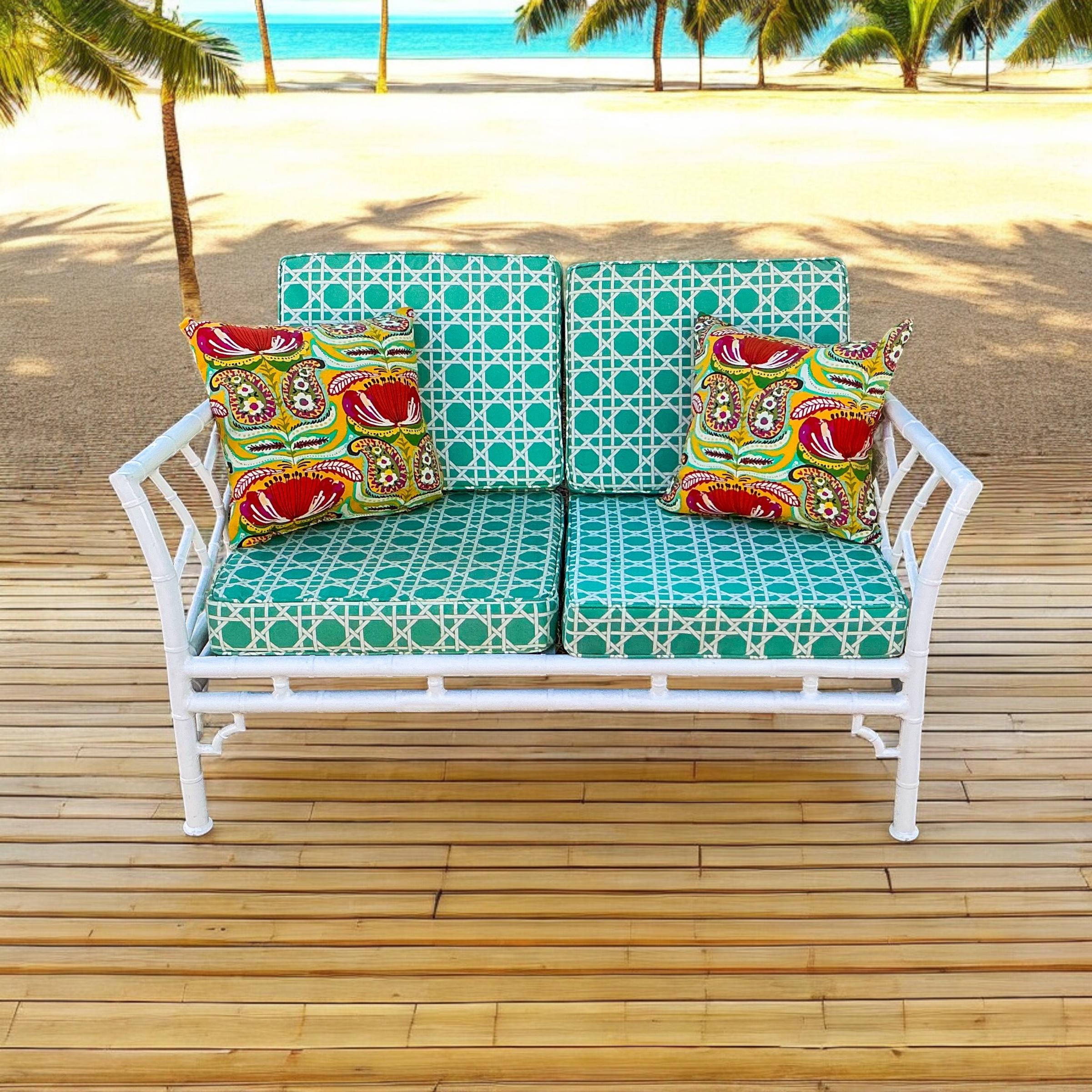 This is a Chinese Chippendale style white faux bamboo settee by Meadowcraft. There are two available. The upholstery is a white lattice / fretwork on a turquoise background. The upholstery is an indoor - outdoor fabric. The frame is marked and is