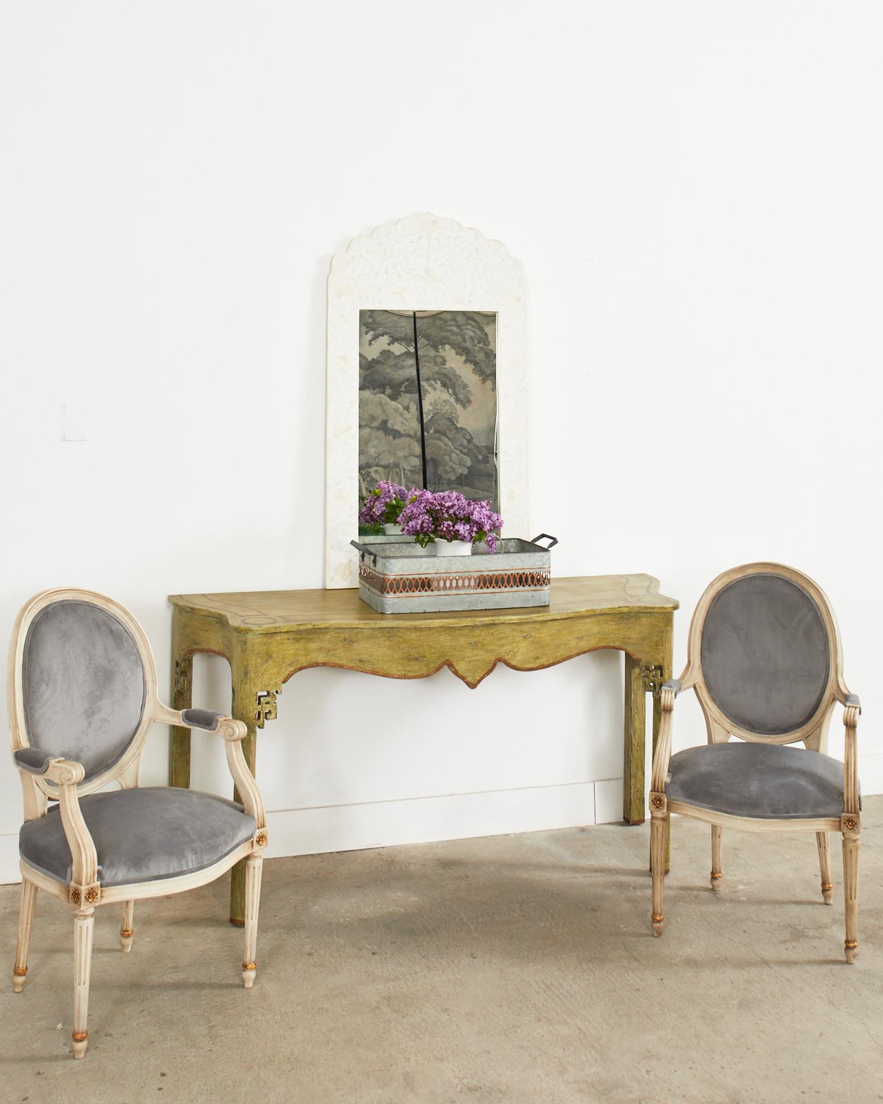 Grand lacquered console table featuring an aged, intentionally distressed patina by Minton-Spidell artisans in Los Angeles, CA. The large table is crafted from a thick, solid plank having a serpentine shaped case. The apron is decorated with Asian