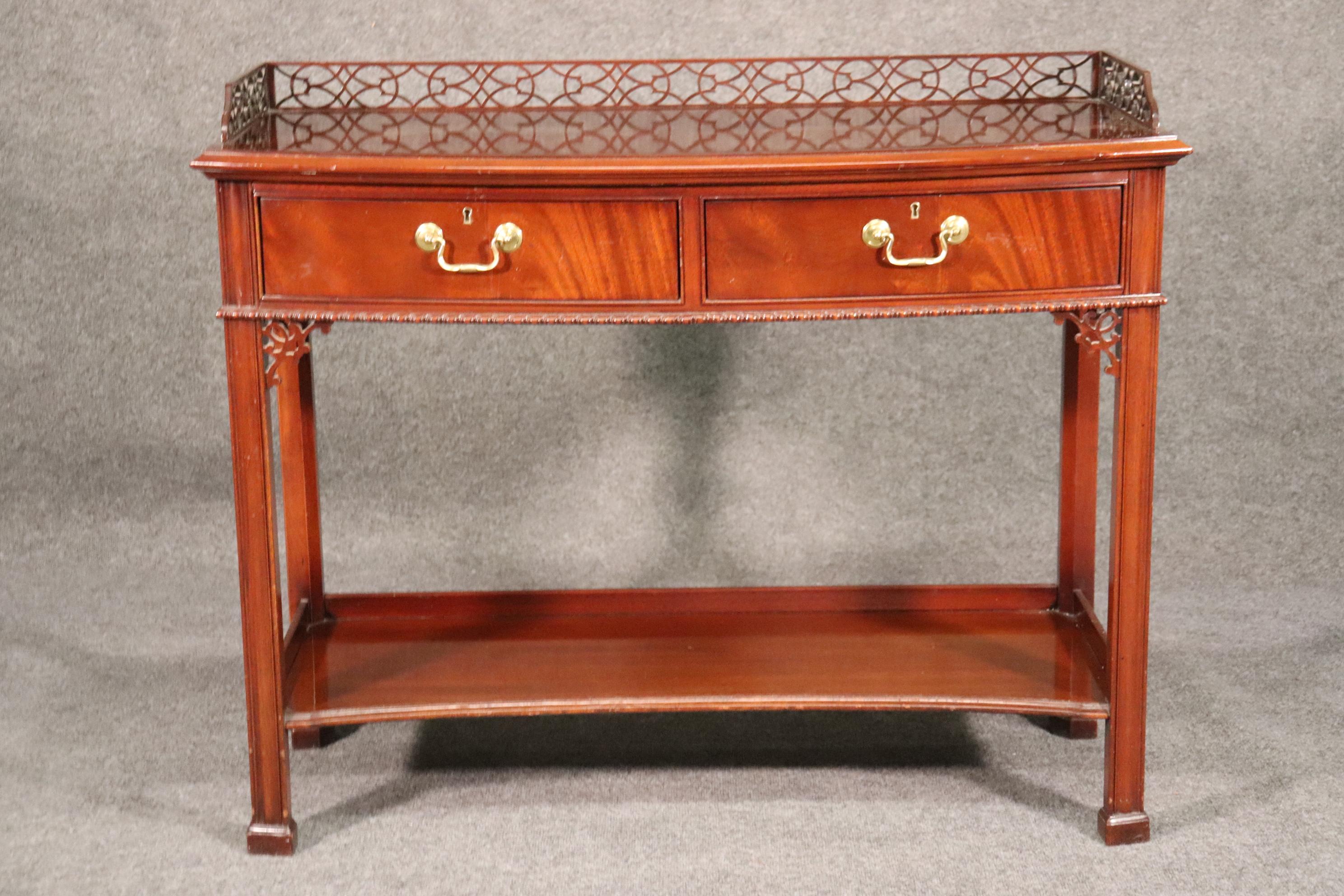 This is a beautiful Hickory chair company console table done in the Chinese Chippendale style. The table is solid mahogany and has oak secondary woods. The table has beautiful carved fretwork around the top and carved brackets too. The table