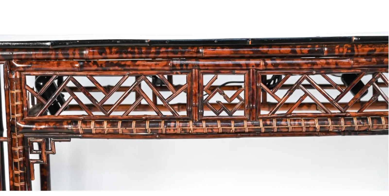 Chinese Chippendale style console with a black lacquer top over a tortoise shell decorated bamboo frame having Chippendale designs. A wonderful and rare striking piece of functional furniture.