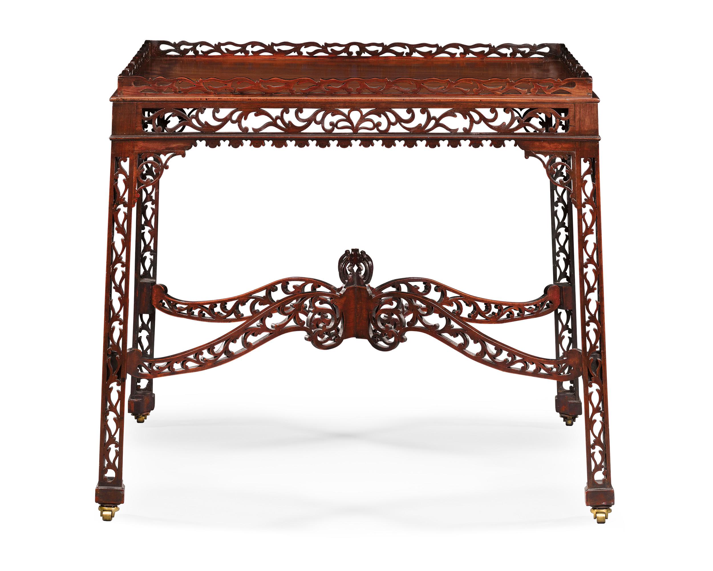 This exquisite English mahogany tea table is a stunning example of the elaborate Chinese Chippendale style. A study in symmetry and balance, this table combines the restrained elegance of the Georgian period with the intricate artistry of the