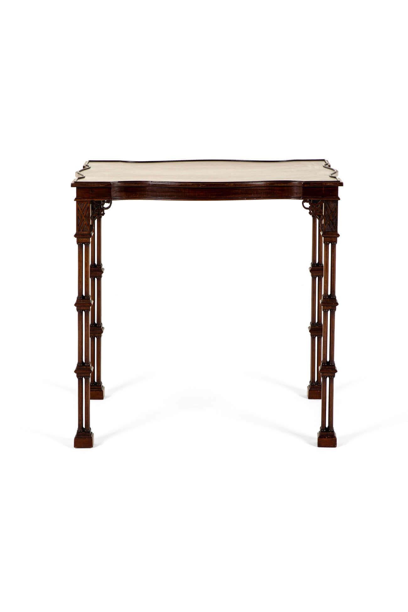 A superb Chinese Chippendale revival silver table in mahogany.

The table has a serpentine rectangular top with a raised double molded edge above a set of cluster column legs on wide classical feet.

Each leg has delicate lattice work carving