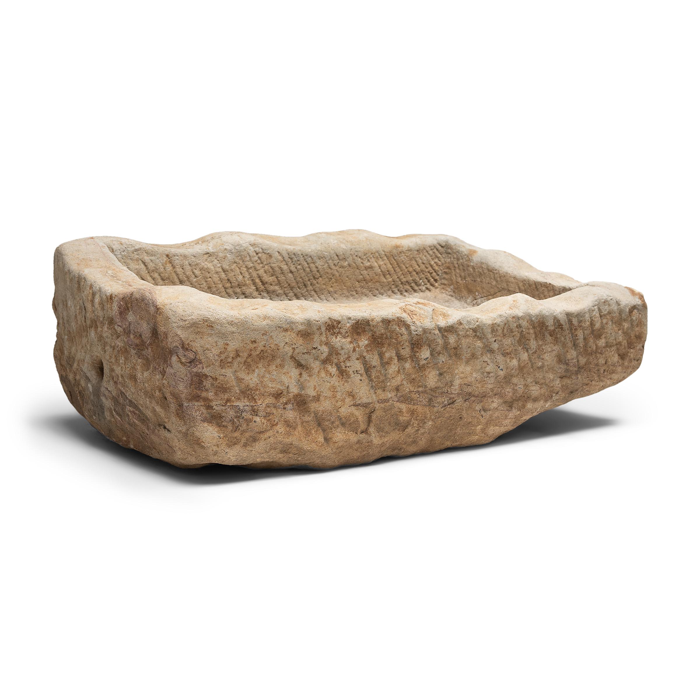 Once used on a Provincial Chinese farm to hold water or animal feed, this early 20th century stone trough is celebrated today for its organic form and rustic authenticity. hand carved from solid limestone, this shallow rectangular trough exists on a