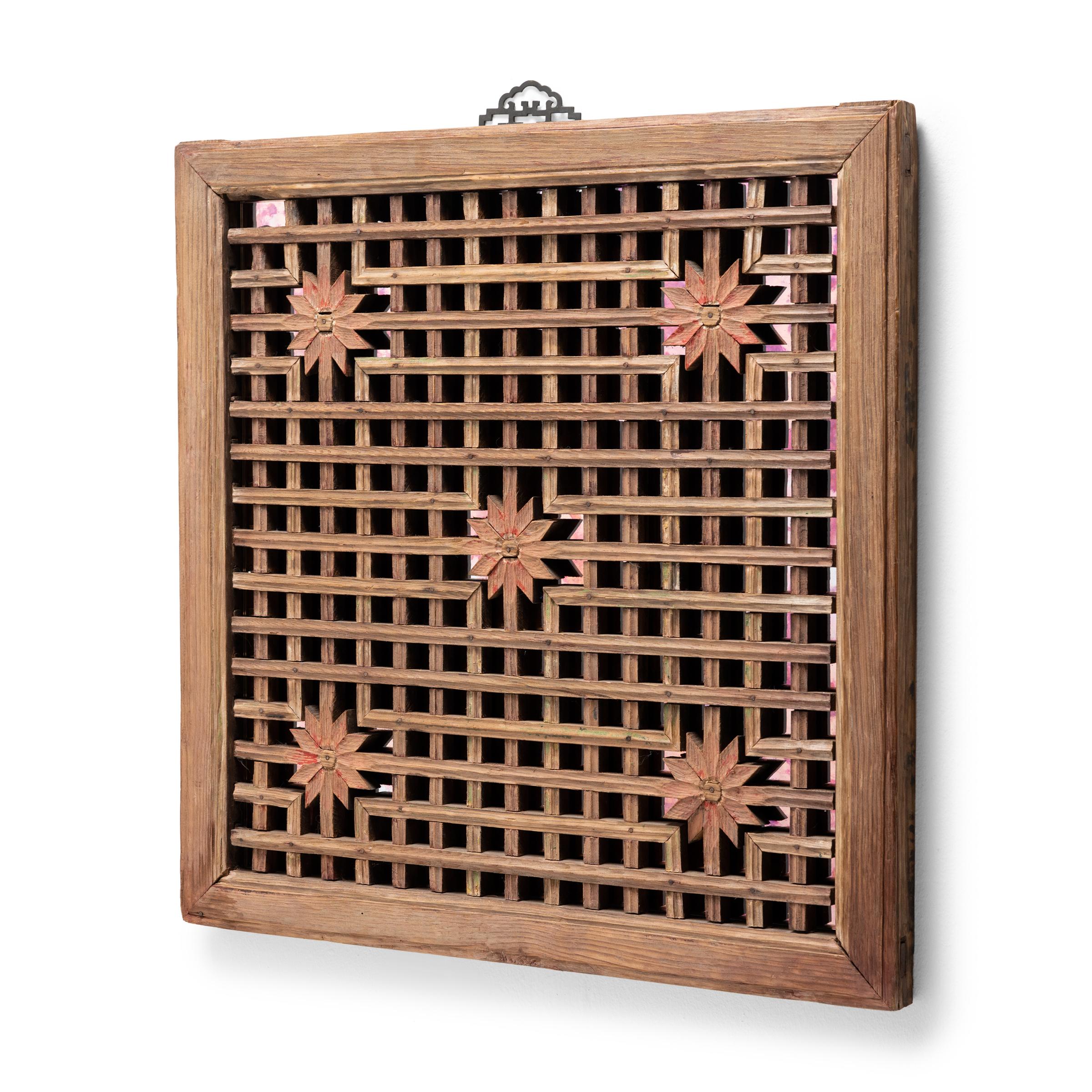 This early 20th century lattice window panel from China's Shanxi province likely originated in a traditional home with balanced interiors. Both functional and decorative, lattice windows allowed for fresh air and light to flow into a room while