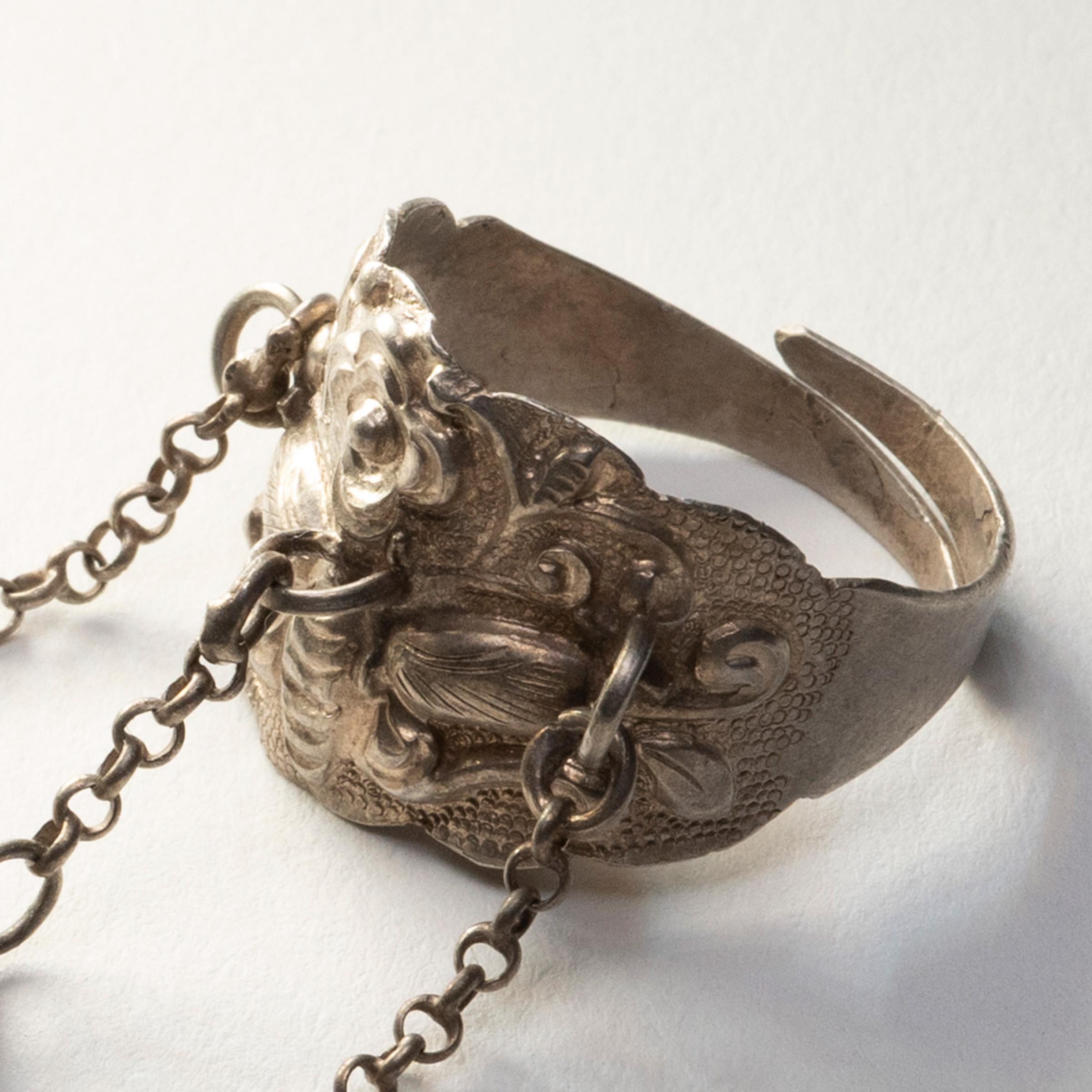 Dated to the late 19th century, this silver-plated charm ring was believed to protect the wearer from bad luck and malevolent spirits. The ring is decorated with a relief design of a cicada surrounded by flowers and curling tendrils. Cicadas have
