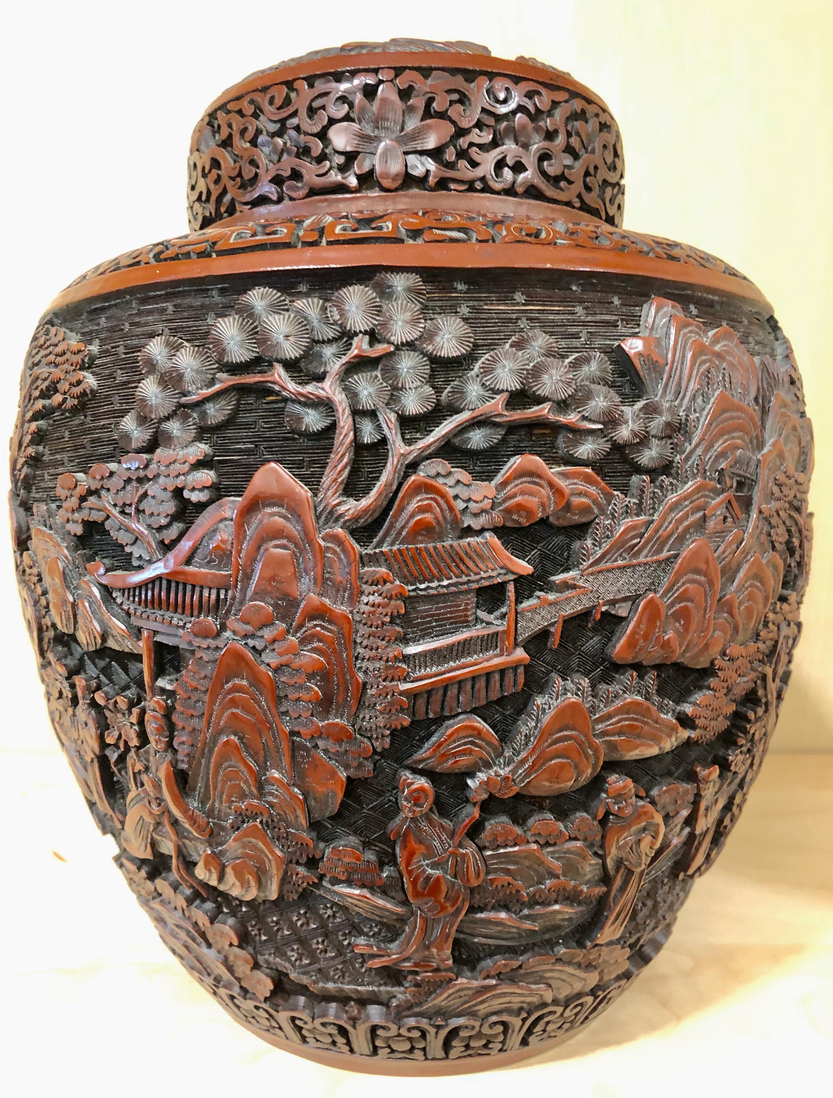 Chinese cinnabar covered jar. Decorated all over with scenes of figures, pavilions, pine trees and mountains. Marked 