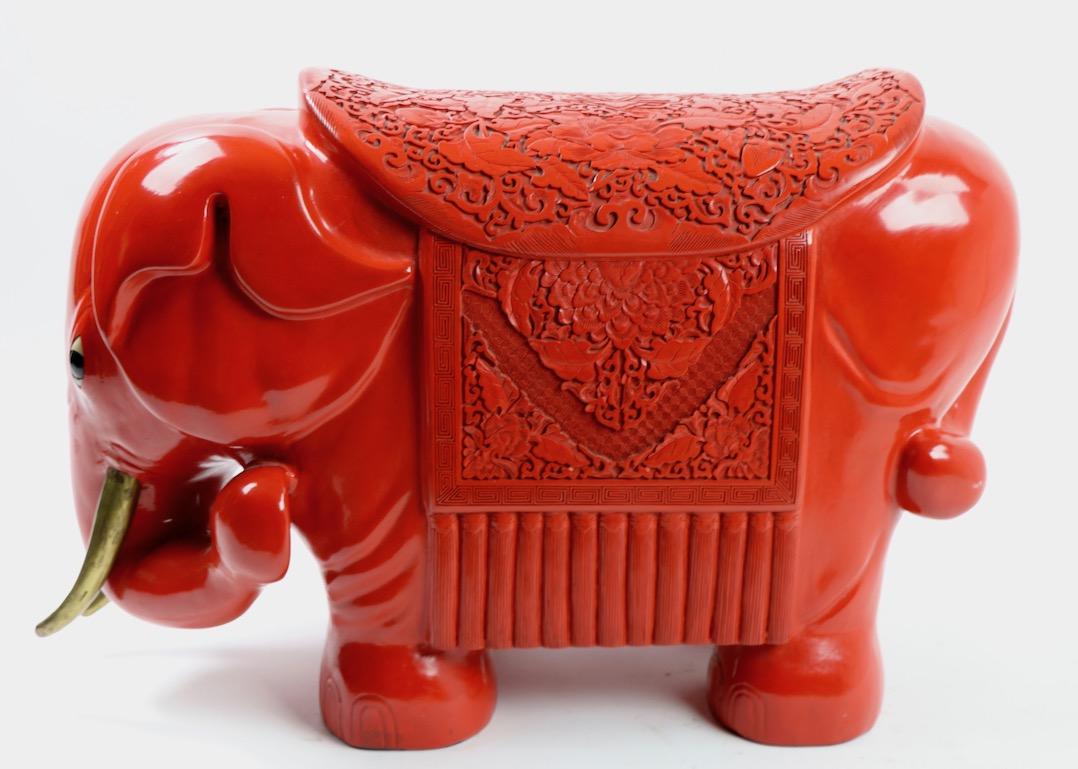 Wonderful decorative elephant figure in red cinnabar. We believe this item is Chinese export, circa 1970s, the elephant shows some loss to the red finish on the top of the hind end, and one truck has been re attached, both issues pictured. Purchased