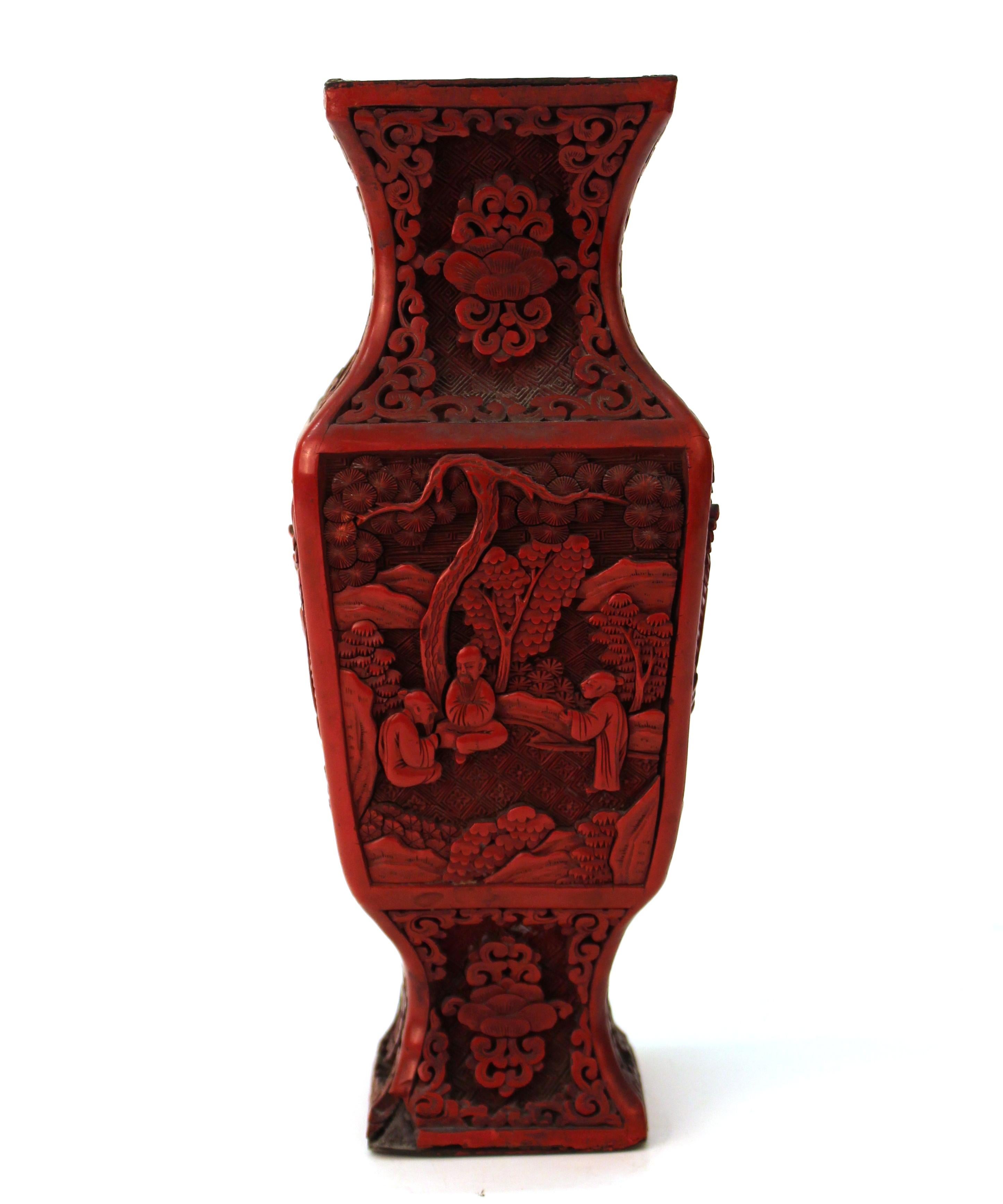 Chinese Cinnabar lacquer vase with carved depictions of sages in classical landscapes and stylized flora and foliage. The piece has a black interior. Some losses to black lacquer on rim of mouth.