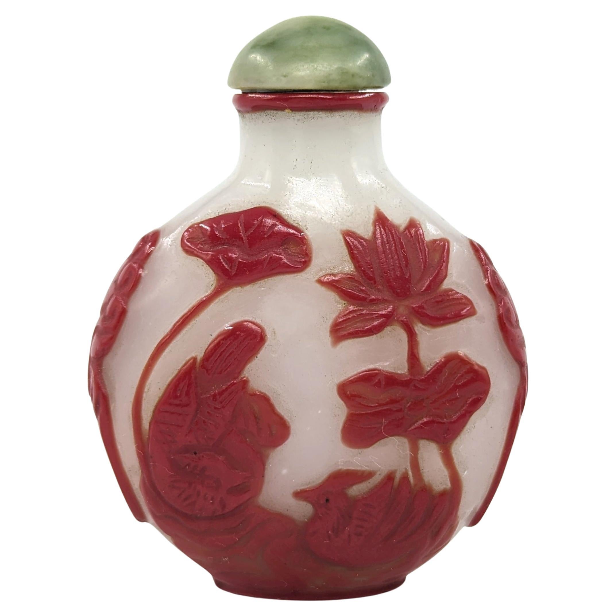 Experience the allure of this Republic period snuff bottle, a vibrant piece that embodies the rich artistic tradition of the time. Crafted with a deep red glass overlay, well imitating the unique color of cinnabar, on milk white ground that serves